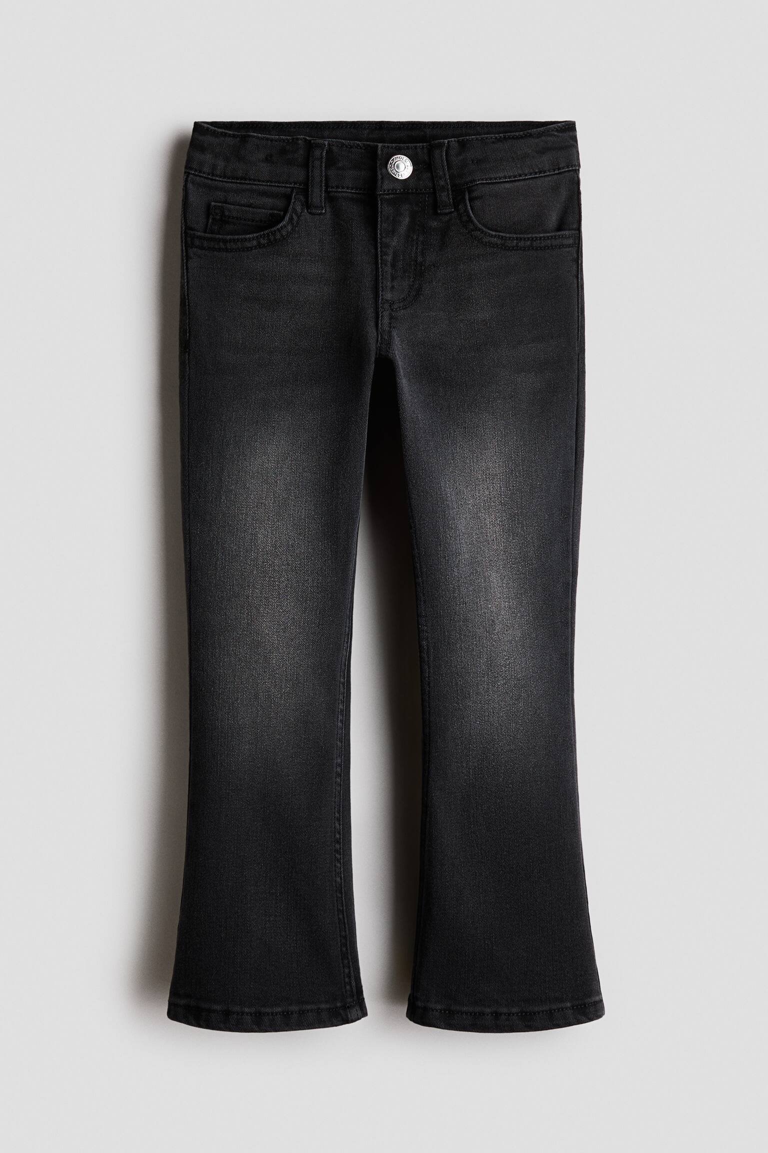 Ãnden gÃ¶rÃ¼nen bir Ã§ift siyah yÄ±kamalÄ± denim jean, hafifÃ§e kloÅ paÃ§a silÃ¼eti ve uyluklarÄ±n ortasÄ±ndan aÅaÄÄ± uzanan soluk detaylarÄ± sergiliyor. Jeanâler, klasik beÅ cepli yapÄ±, kemer kÃ¶prÃ¼leri ve bel kÄ±smÄ±nda tek gÃ¼mÃ¼Å tonlu dÃ¼Äme kapama ile tasarlanmÄ±ÅtÄ±r.