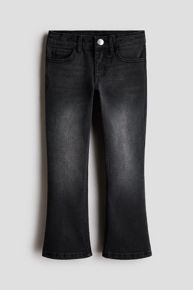 A pair of black washed denim jeans is shown from the front, featuring a slightly flared leg silhouette and faded detailing down the centre of the thighs. The jeans feature a classic five-pocket construction, belt loops, and a single silver-tone button closure at the waistband. - 1