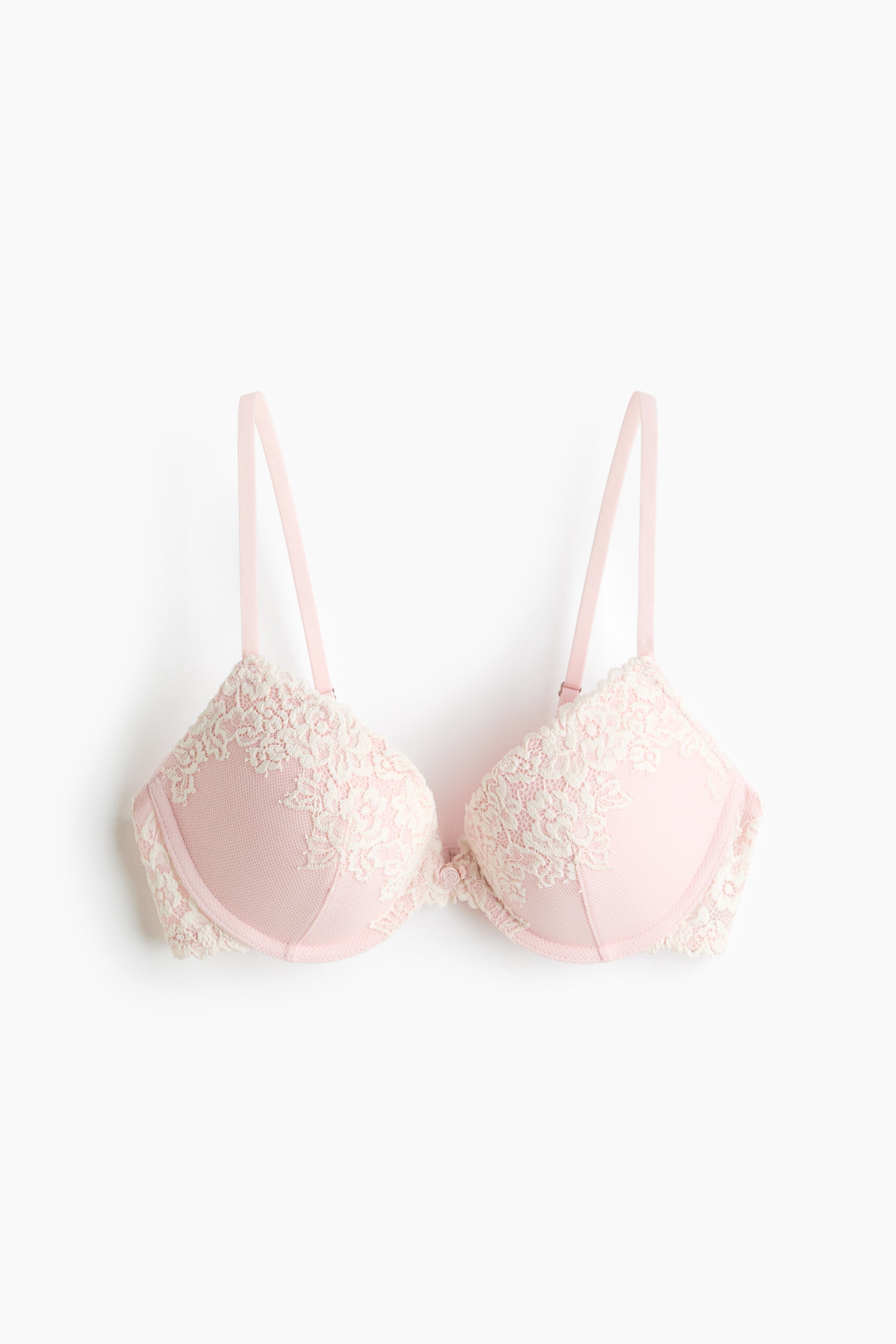 View larger image: A pink push-up bra is shown from the front, featuring pink mesh cups overlaid with white floral lace. It has adjustable pink shoulder straps and underwired, padded cups.