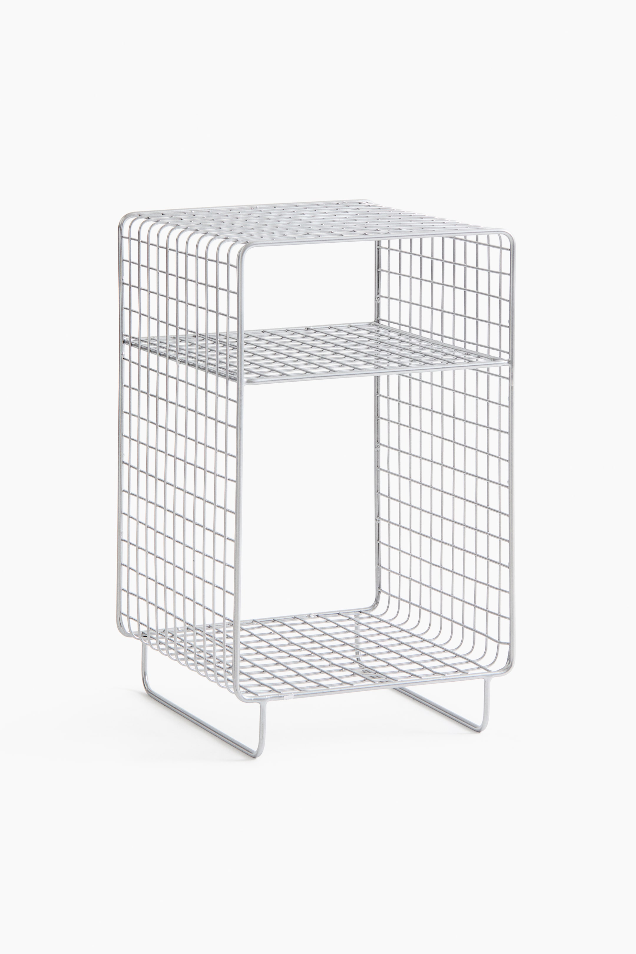 View larger image: A silver-coloured wire shelving unit is showcasing a grid design with rounded corners, viewed from a slight front-right angle. It features one internal shelf and two U-shaped wire legs as its base.