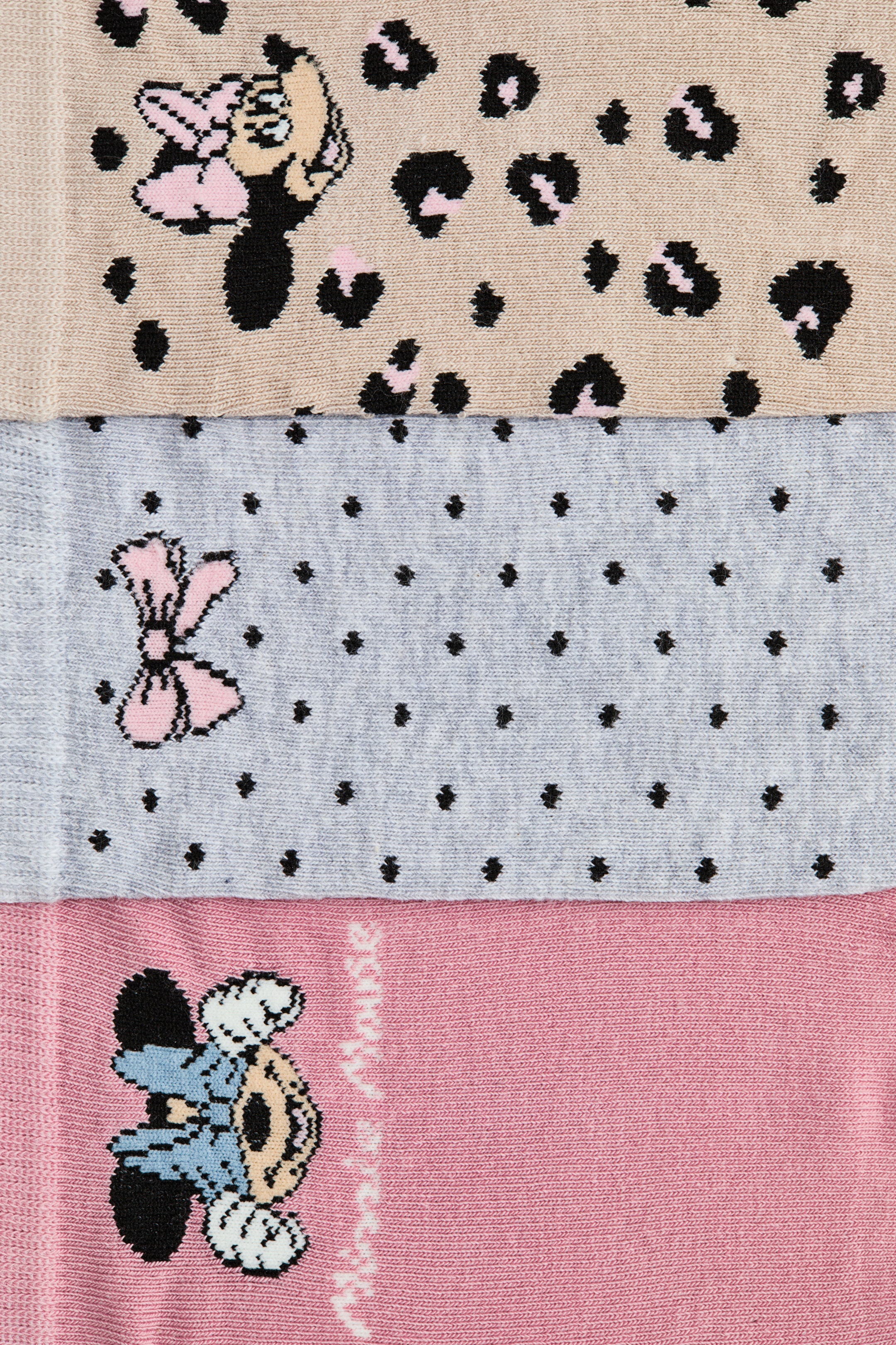 Grotere afbeelding bekijken: Sokloze sokken in een zachte, fijngebreide katoenmix worden gepresenteerd, met drie verschillende ontwerpen op de voorkant. De ontwerpen omvatten een beige sok met zwarte en roze luipaardprint en een Minnie Mouse-graphic, een lichtgrijze sok met zwarte stippen en een roze strik-graphic, en een roze sok met een Minnie Mouse-graphic en de tekst "Minnie Mouse".