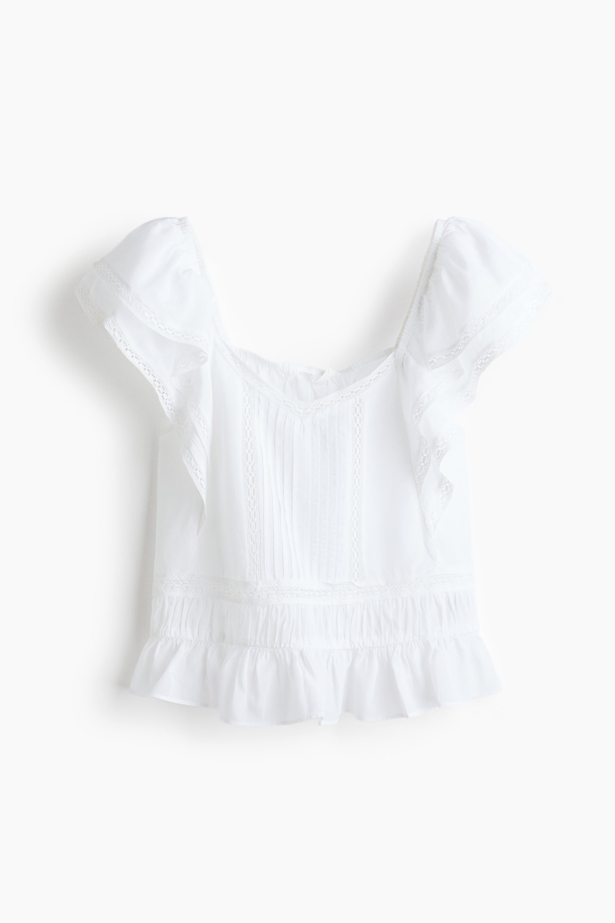 Grotere afbeelding bekijken: Een witte blouse toont zijn voorkant, met een V-vormige halslijn en dubbele lagen vlindermouwen met bedekte elastiek over de schouders. De voorkant is gedetailleerd met kanten afwerkingen en pintucks, leidend tot geplooide naden en een zoom met ruches.
