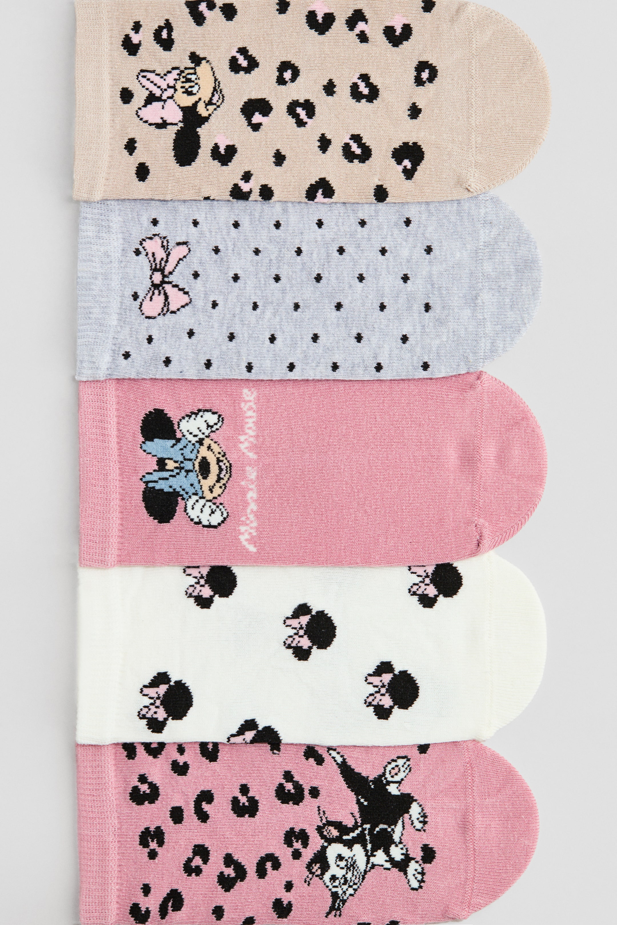 Grotere afbeelding bekijken: Sokloze sokken worden verticaal gestapeld en van voren gepresenteerd. Ze bevatten verschillende Minnie Mouse-thema ontwerpen, waaronder luipaardprints, stippen en karakterillustraties, en allemaal tonen ze een fijngebreide textuur met elastische boorden.