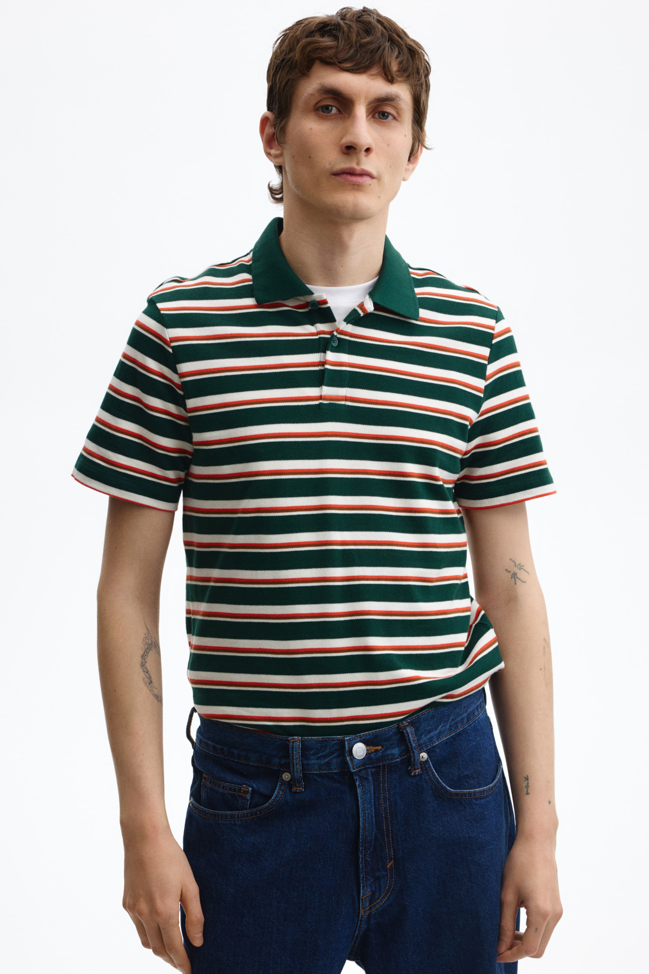 View larger image: Front-facing polo shirt featuring horizontal stripes in dark green, white, and rust orange. It has a dark green collar and a two-button placket, layered over a white T-shirt.