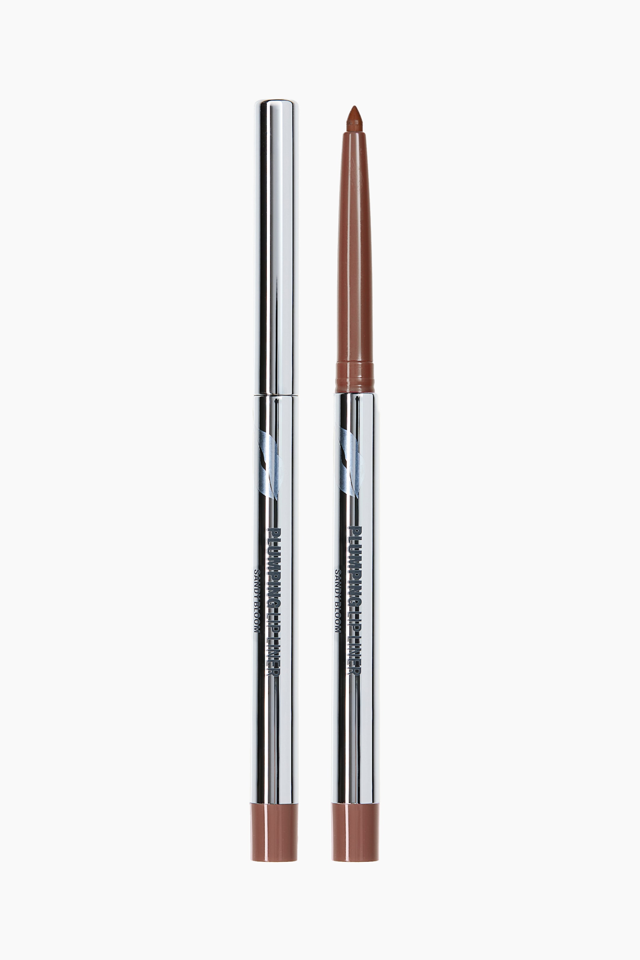 Ampliar la imagen: Dos delineadores de labios cilíndricos están de pie, mirando al frente, ambos con un barril metálico plateado brillante con el texto "PLUMPING LIP LINER" y "SANDY BLOOM", y un indicador de color marrón en la base. Uno de los delineadores está tapado con una tapa metálica plateada, y el otro está destapado, revelando una punta de delineador de labios marrón afilada.