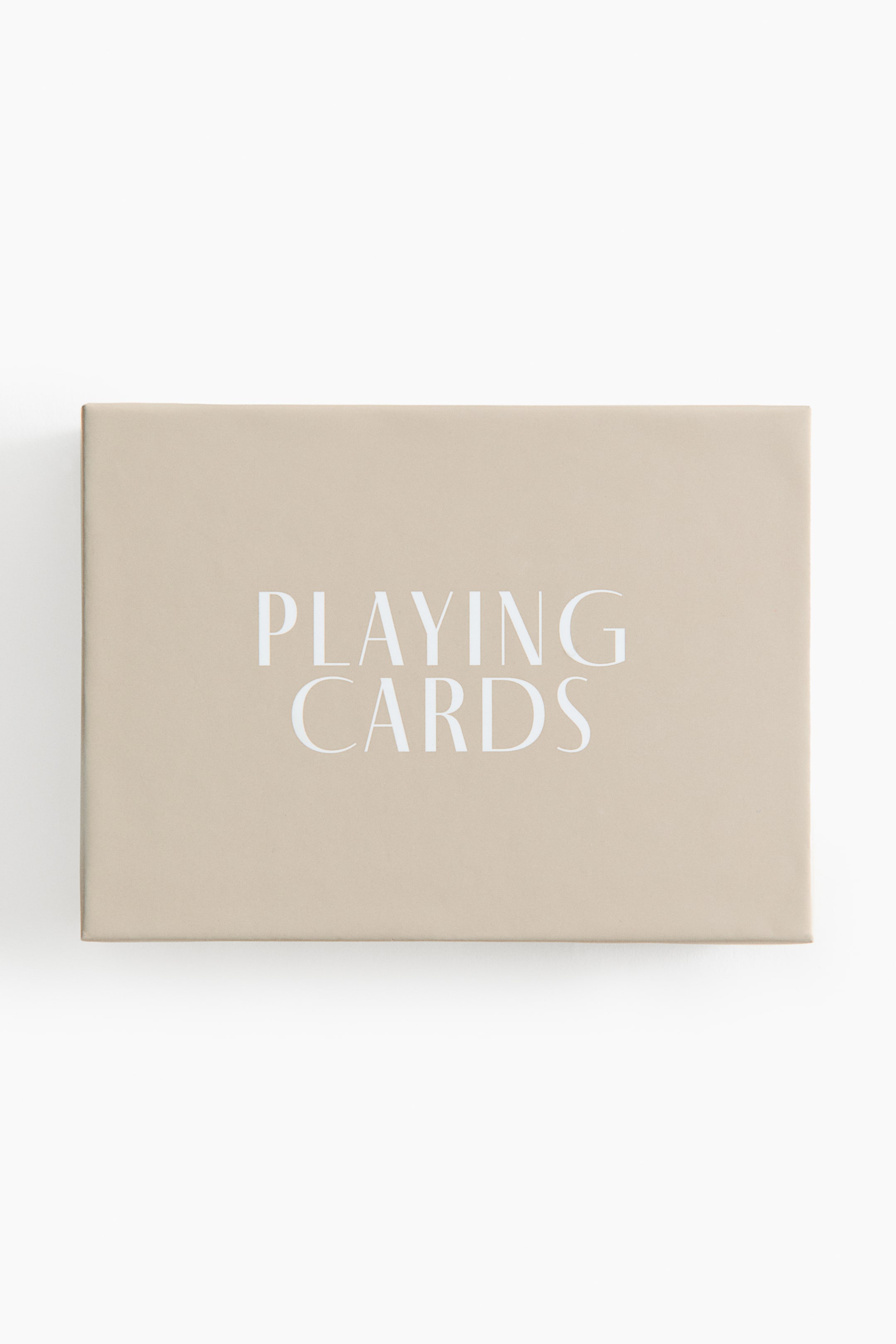 View larger image: A rectangular, light beige box of playing cards is shown facing forward. The words 'PLAYING CARDS' are printed in white, sans-serif capital letters across its top surface.