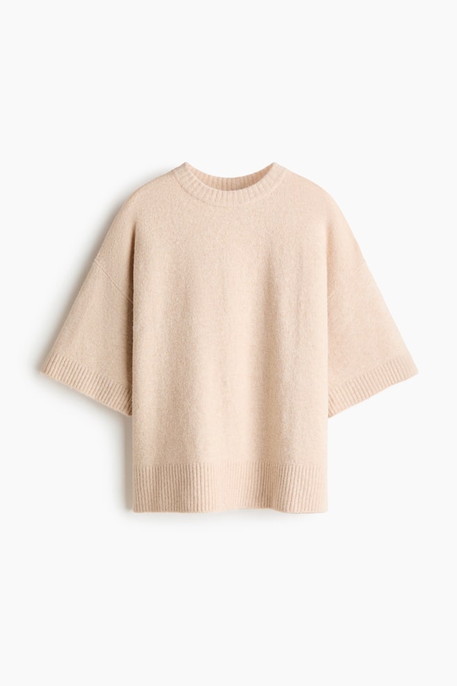 A light beige jumper featuring a crew neck and short, wide sleeves. It showcases a soft, fuzzy knit texture with ribbed details at the neckline, sleeve cuffs, and bottom hem. - 1