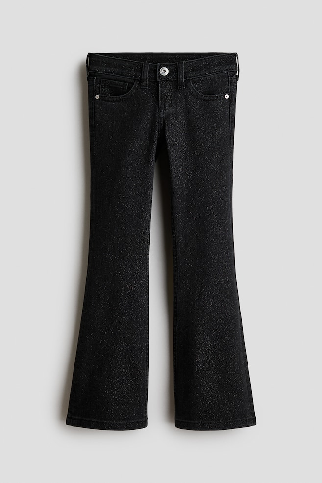 Black washed cotton denim jeans are shown from the front, featuring a low-rise waist with a button closure and zip fly. The jeans feature a classic five-pocket design with a slim fit through the hips and thighs that flares out into the legs. - 1