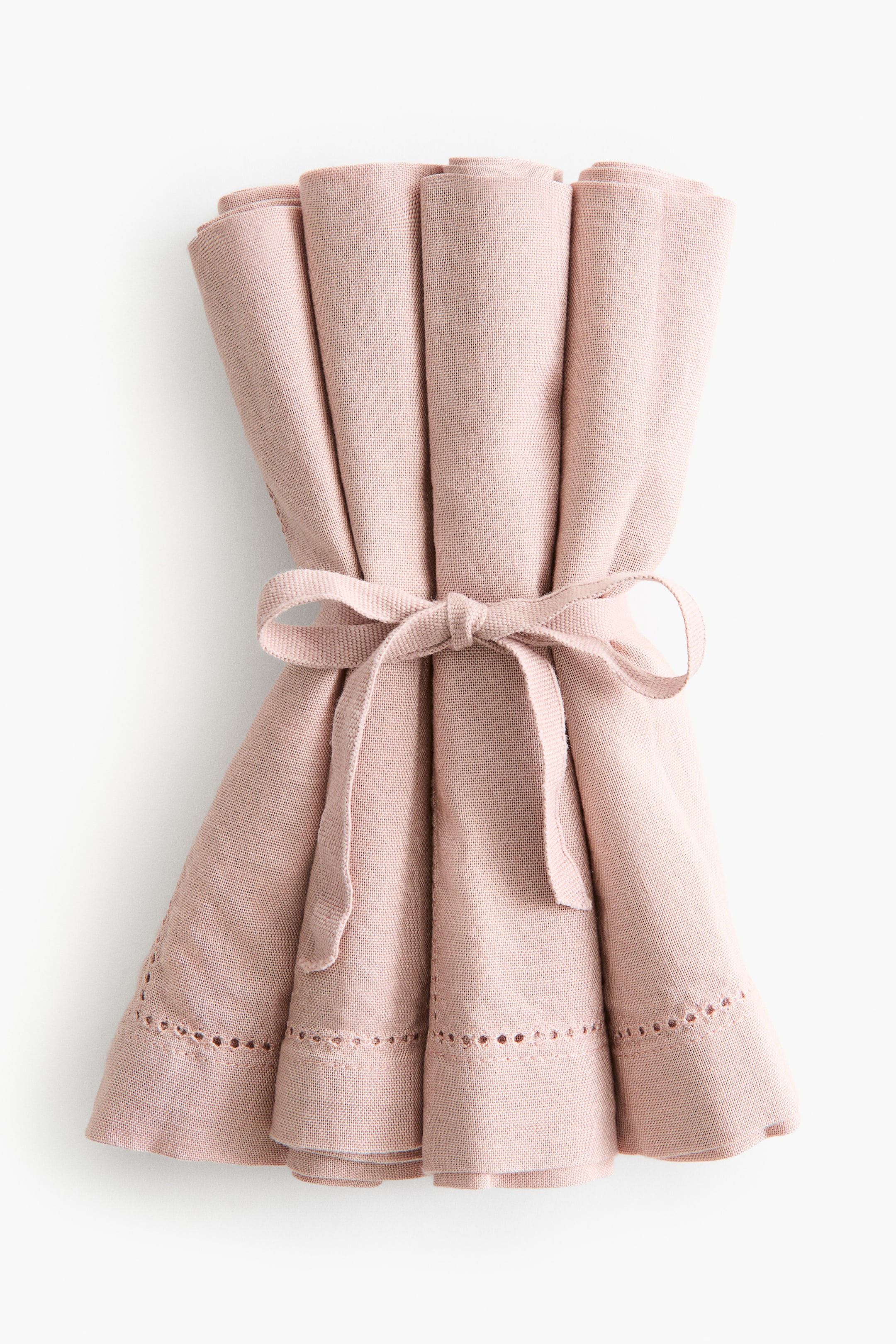 Ver imagen más grande: Servilletas de algodón tipo canvas en rosa pálido, dobladas y agrupadas, sujetas con una cinta de tela a juego que forma un lazo y presentan un detalle de vainica a lo largo de sus dobladillos de 2,5 cm.