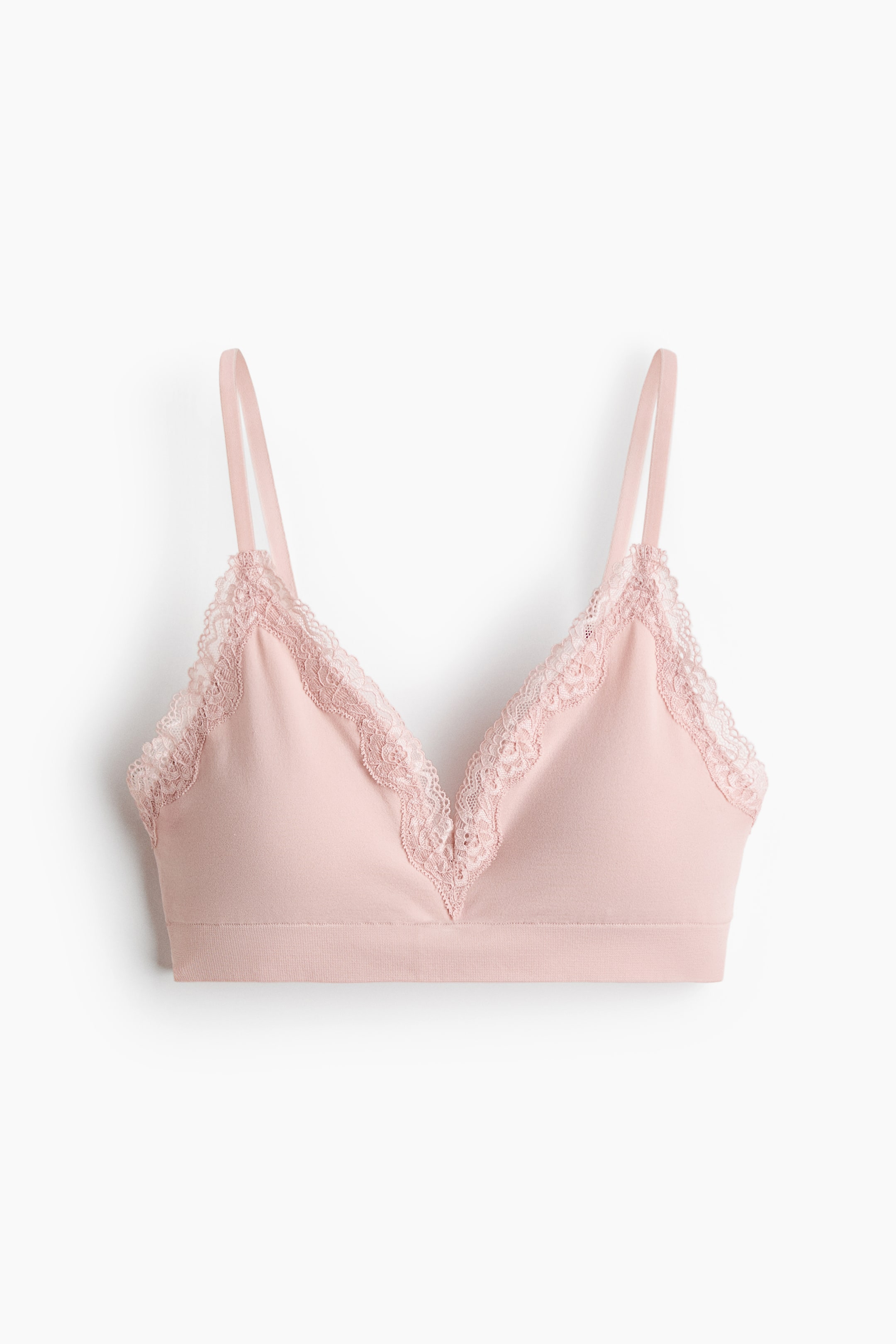 View larger image: A light pink bralette is featuring triangle cups with scalloped lace trim detailing the V-neckline and upper edges, facing forward. It has thin shoulder straps and a wide, elasticised band forming the bottom.