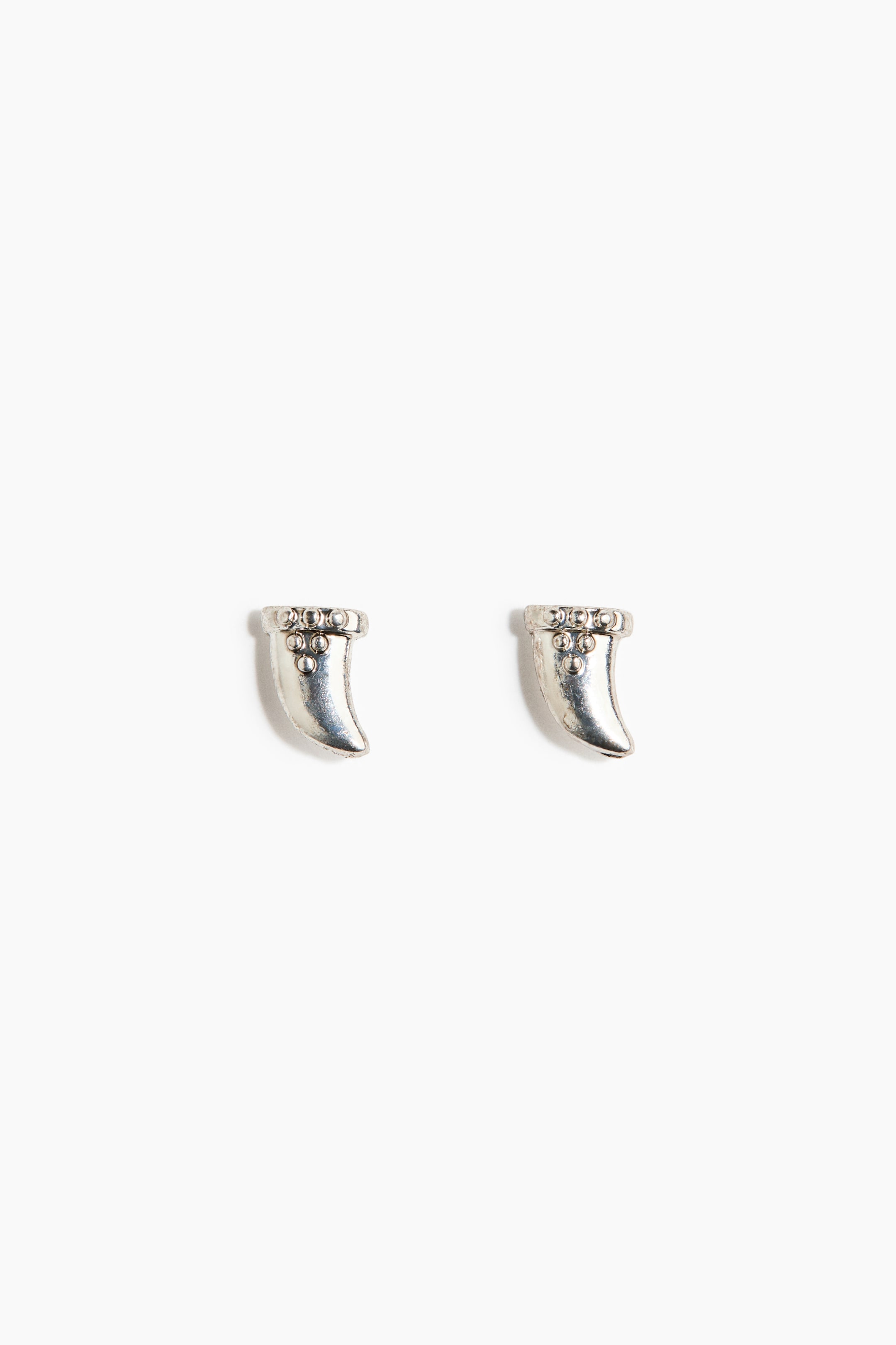 View larger image: Two silver horn-shaped earrings are shown from the front. Each earring features a curved, pointed silhouette with a decorative band of raised circular dots at the top, and three additional dots arranged in a triangular pattern below.