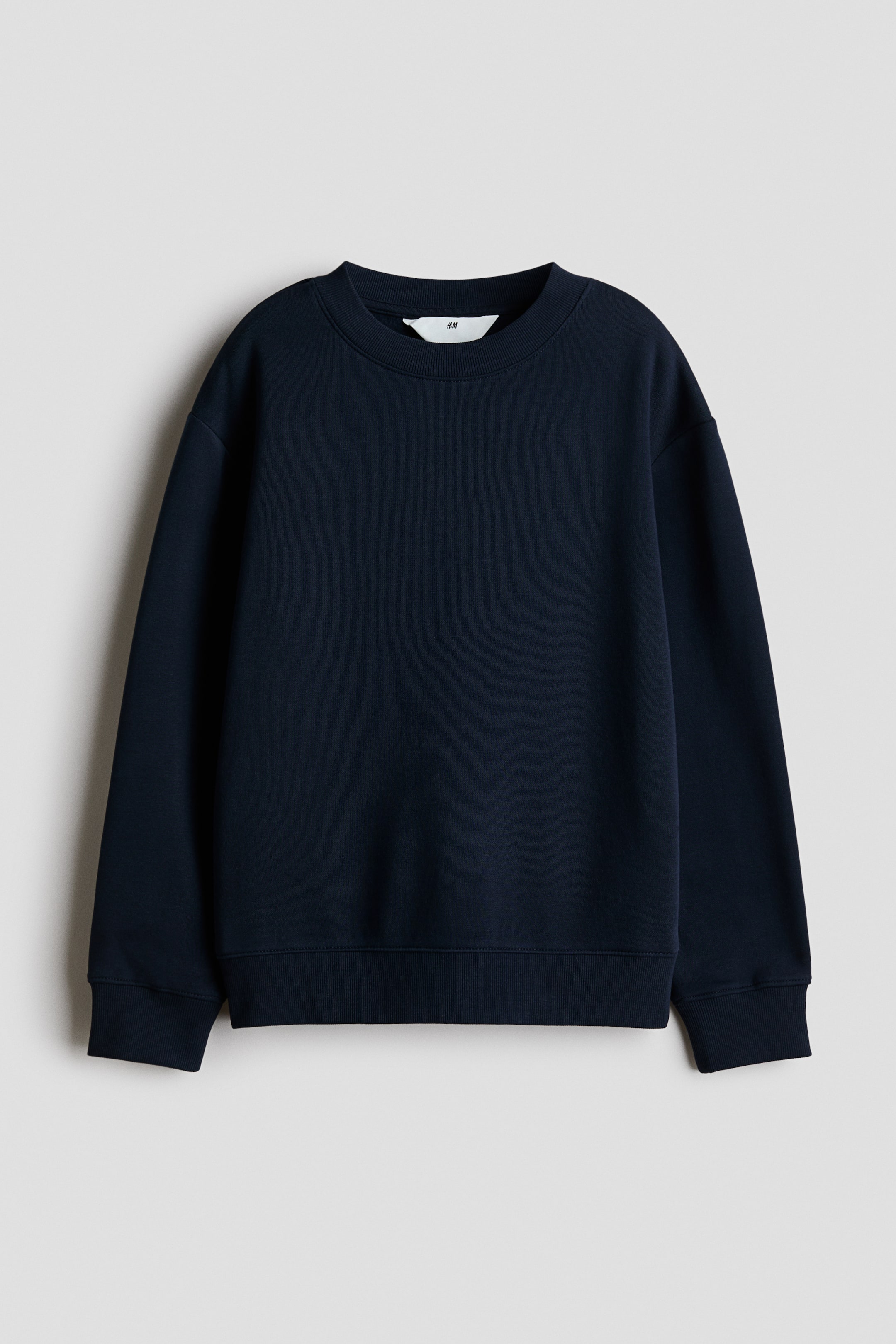 View larger image: A navy blue sweatshirt is shown from the front, featuring a round, rib-trimmed neckline with a visible white H&M tag, dropped shoulders, long sleeves, and ribbed cuffs and hem.