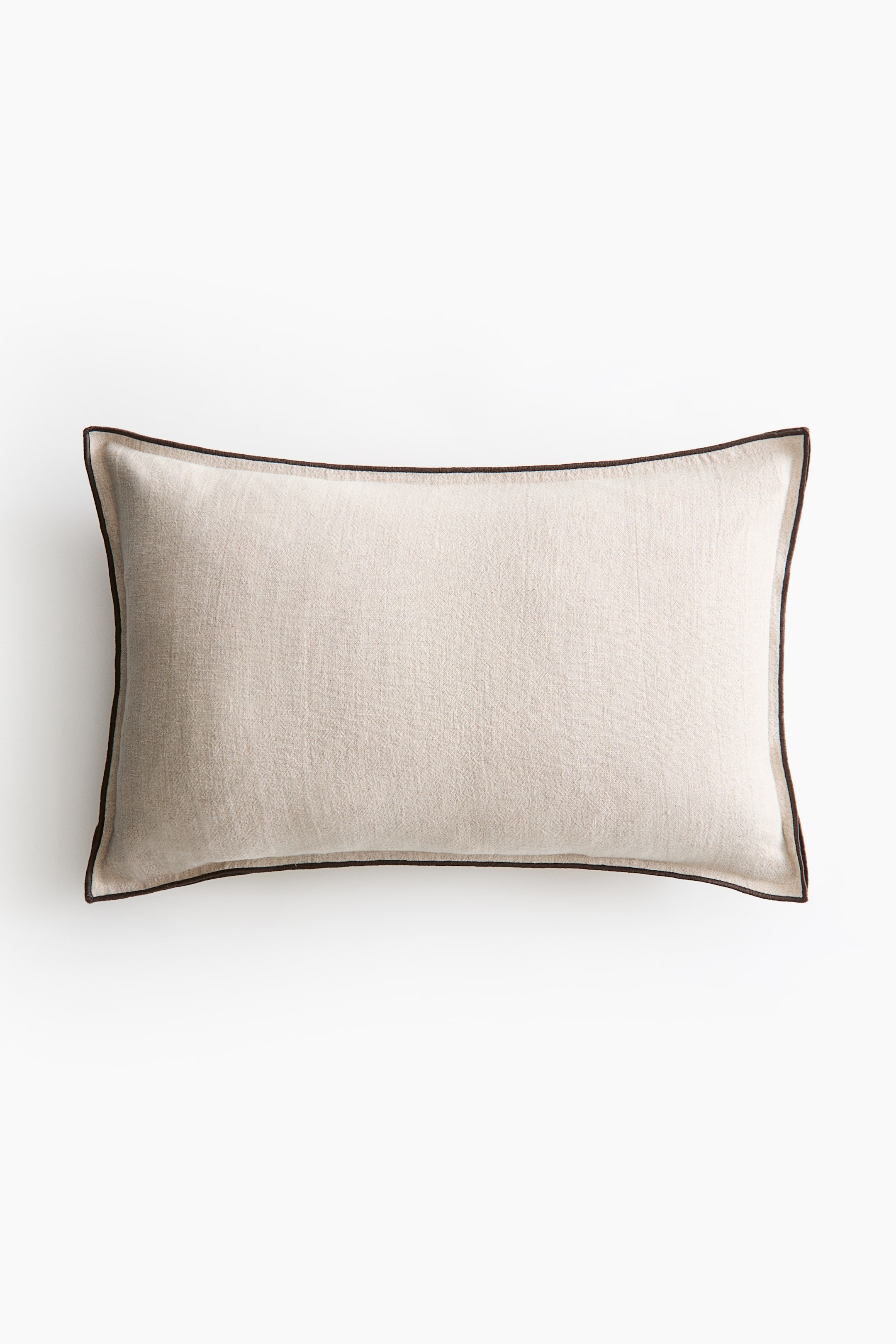 View larger image: A rectangular pillow showcases a light beige, textured fabric on its front, with dark brown piping outlining all four edges.