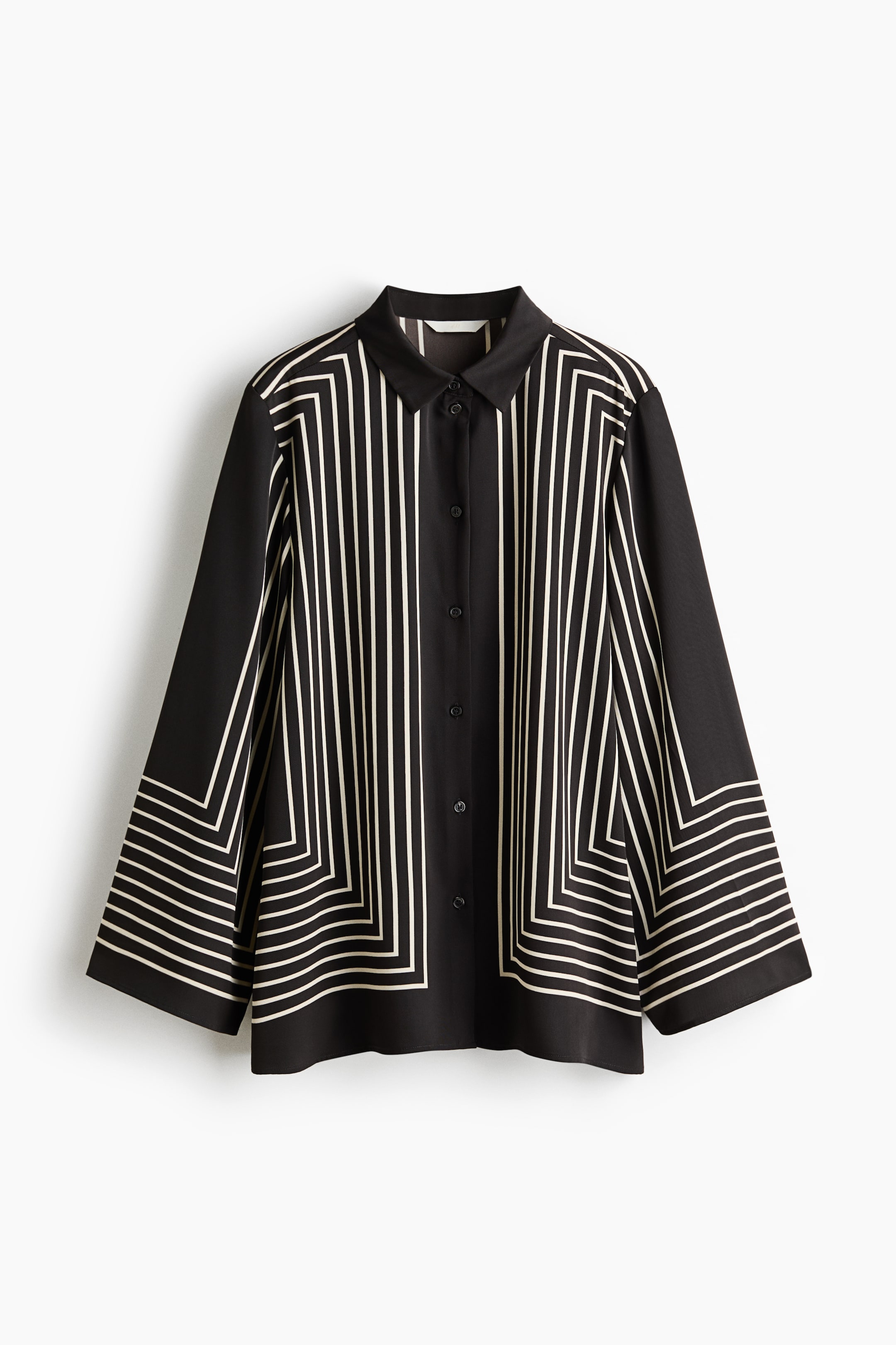 查看大圖: 一件黑色襯衫，飾有米白色線條的幾何圖案，由正面展示。中央有垂直線條向下延伸，於袖子及下擺過渡為同心方形圖案；設有尖領，前襟為排扣設計，配以黑色鈕扣。