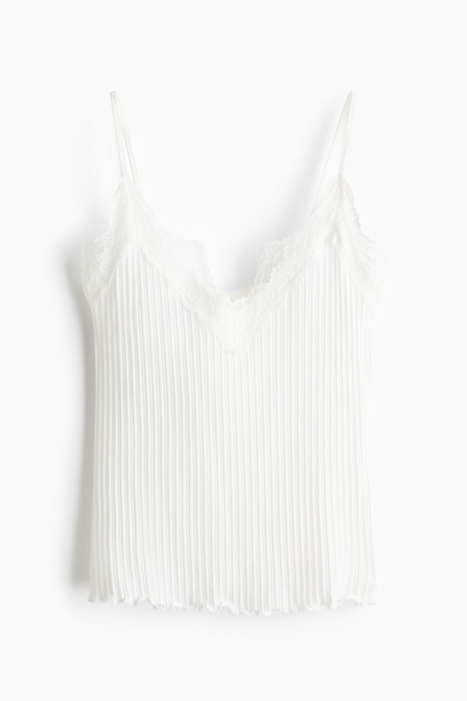 A white camisole is displaying a vertically pleated texture across its front, featuring a V-neckline with delicate lace trim and thin spaghetti straps. The bottom hem is showing a subtle scalloped edge. - 1