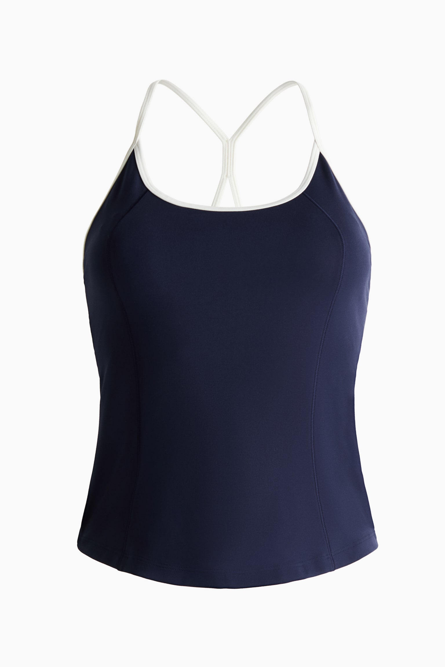 A navy blue athletic tank top is shown from the front, featuring a scoop neckline with contrasting white trim and thin white shoulder straps that connect in a Y-back style. The fitted top showcases vertical princess seams along the front panels and a straight hem.