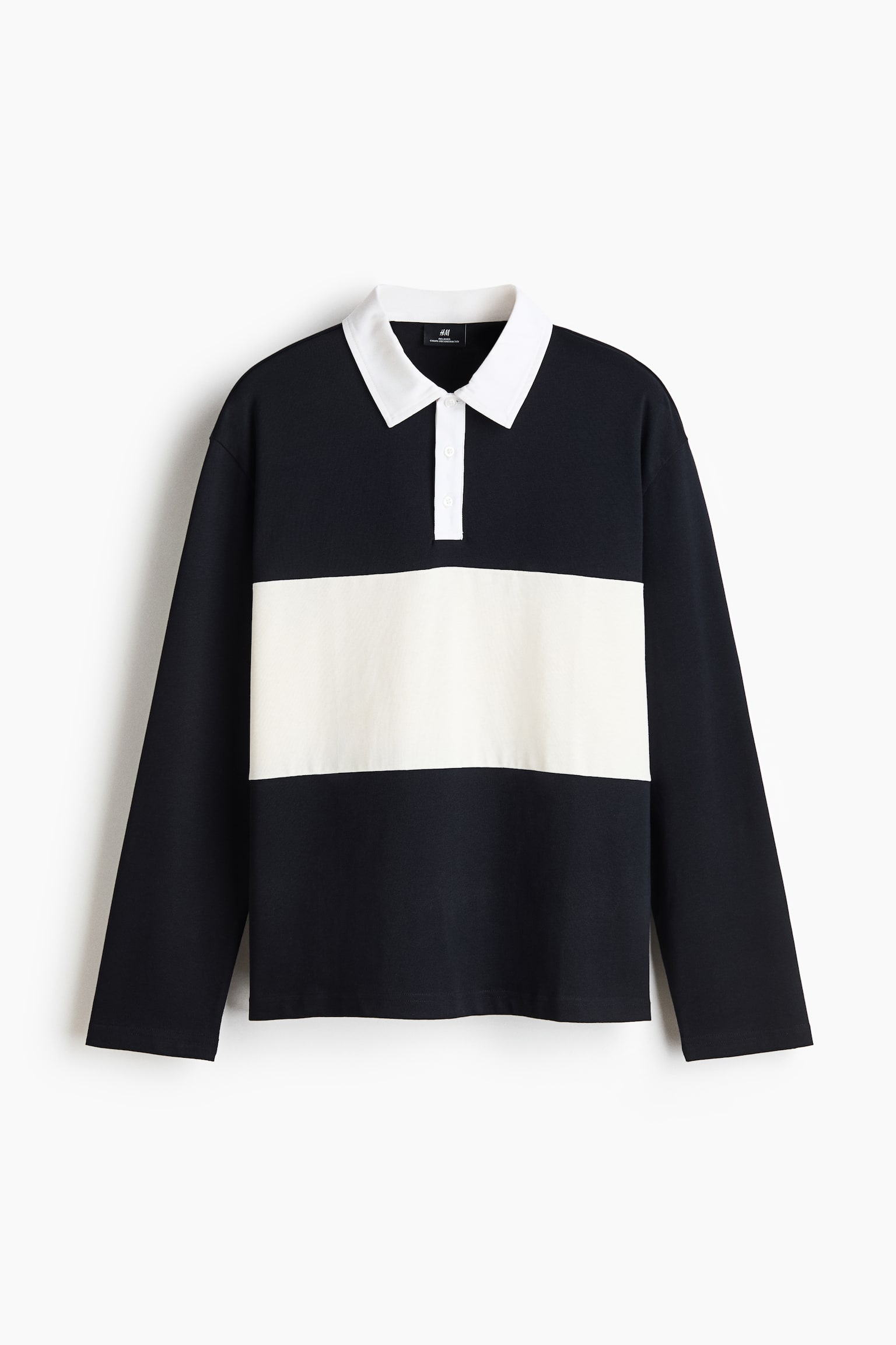 A long-sleeved rugby shirt is shown from the front, featuring a black body with a wide horizontal white band across the chest. It has a contrasting white polo collar, a white button placket, and long sleeves with neatly finished cuffs.