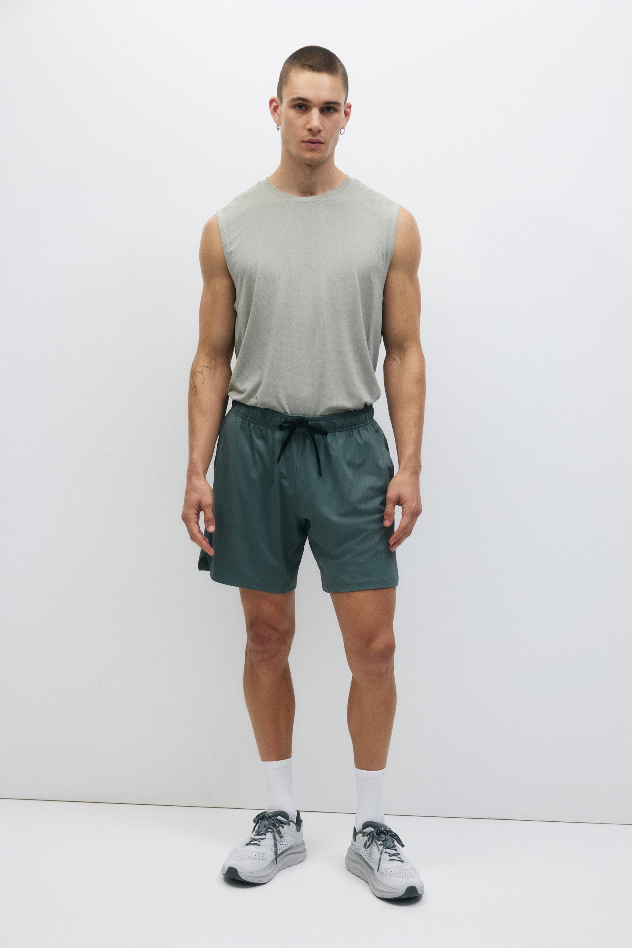 Grösseres Bild ansehen: DryMove Sportshorts präsentieren sich in der Vorderansicht mit einem elastischen Bund und einem schwarzen Kordelzug. Sie zeigen eine lockere Passform, die oberhalb der Knie endet, in einem dunklen Türkis.