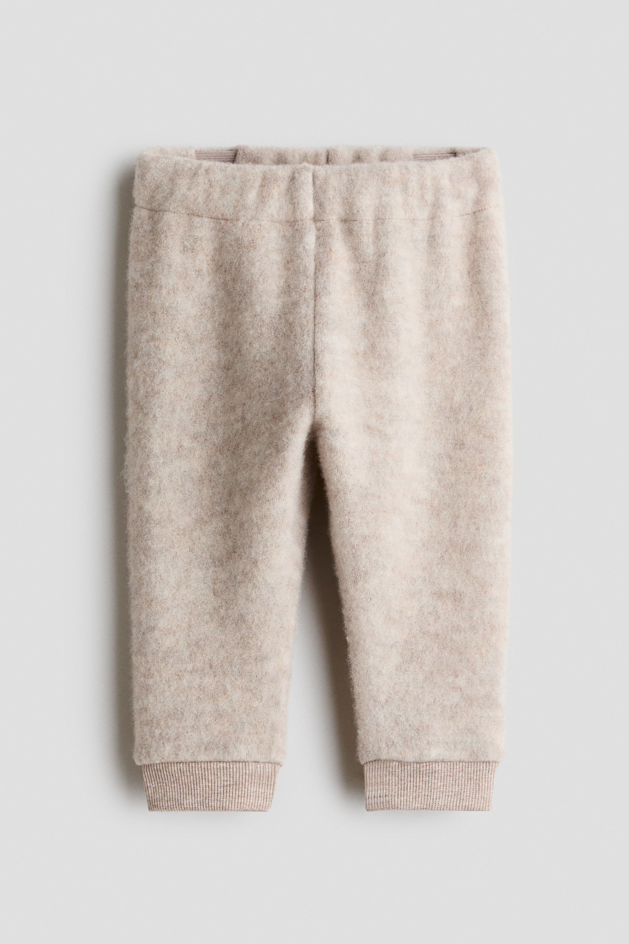 Visualizza l'immagine ingrandita: Pantaloni color avena con una morbida texture in maglia effetto peluche. Sono realizzati con una vita elasticizzata e polsini a costine alla caviglia.