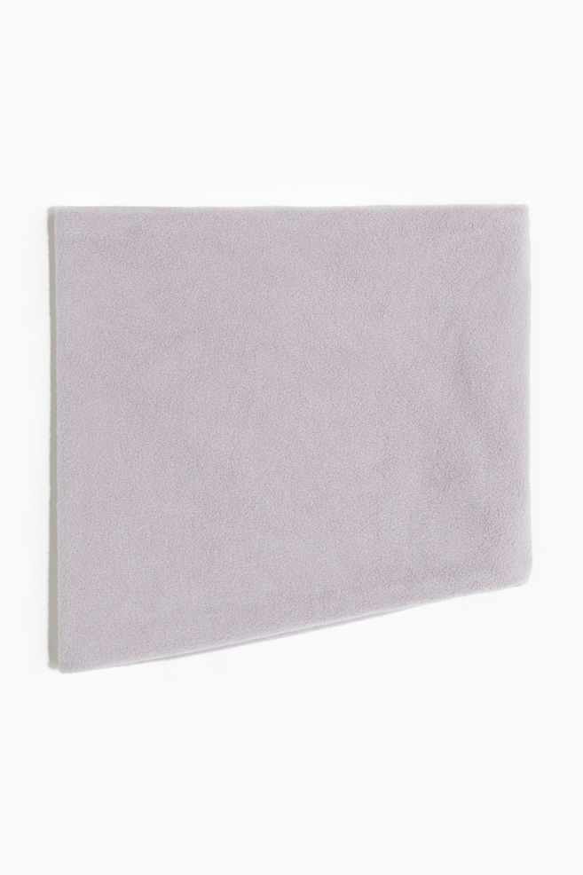 A light purple fleece fabric piece is lying flat, displaying its soft, textured surface and a rectangular shape with an angled cut on the bottom right. - 1
