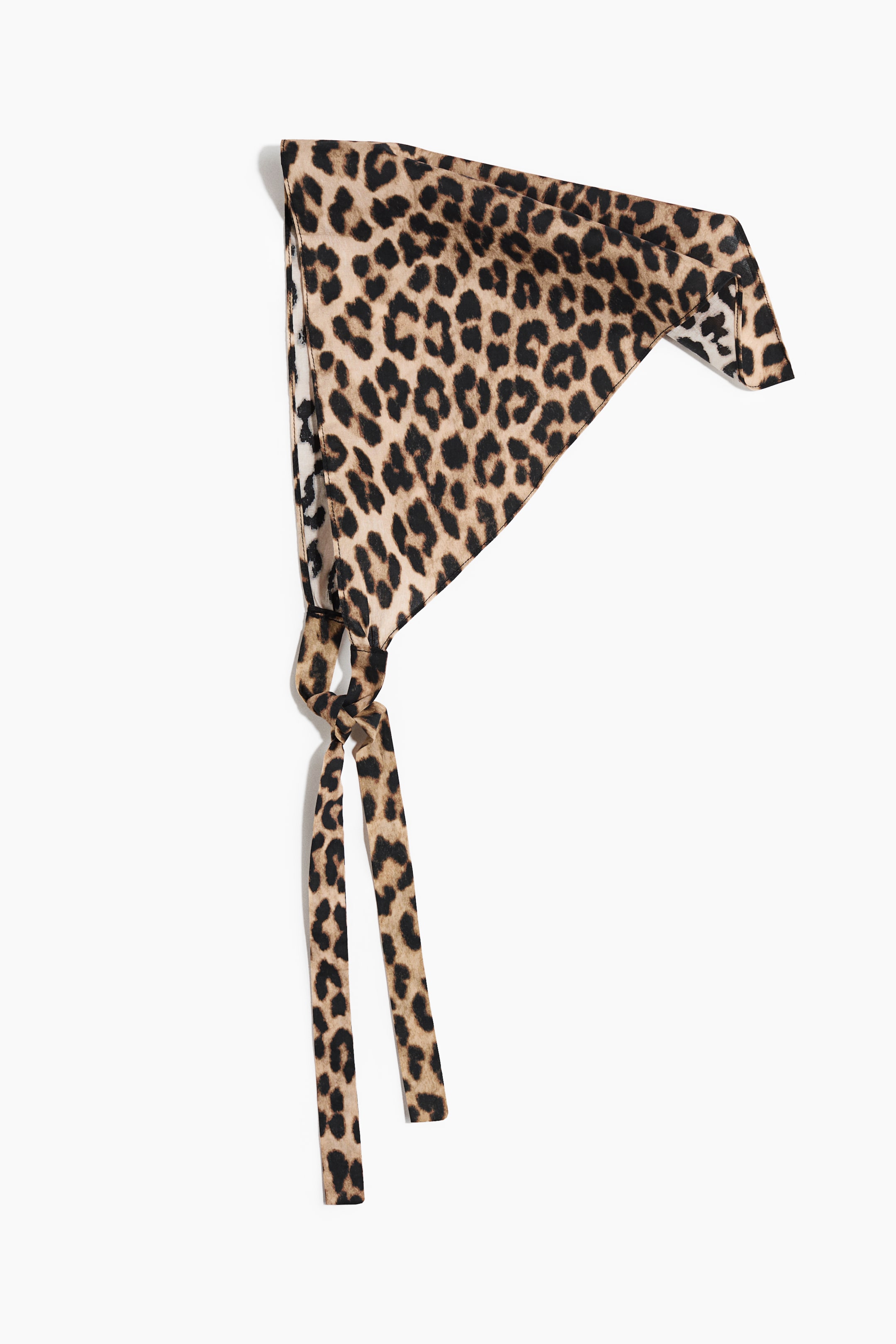 Zobacz większy obraz: Trójkątna bandana ma brązowy i czarny wzór w cętki lamparta. Jest zawiązana na supeł w pobliżu jednego rogu, z dwoma długimi, wąskimi końcami zwisającymi w dół.