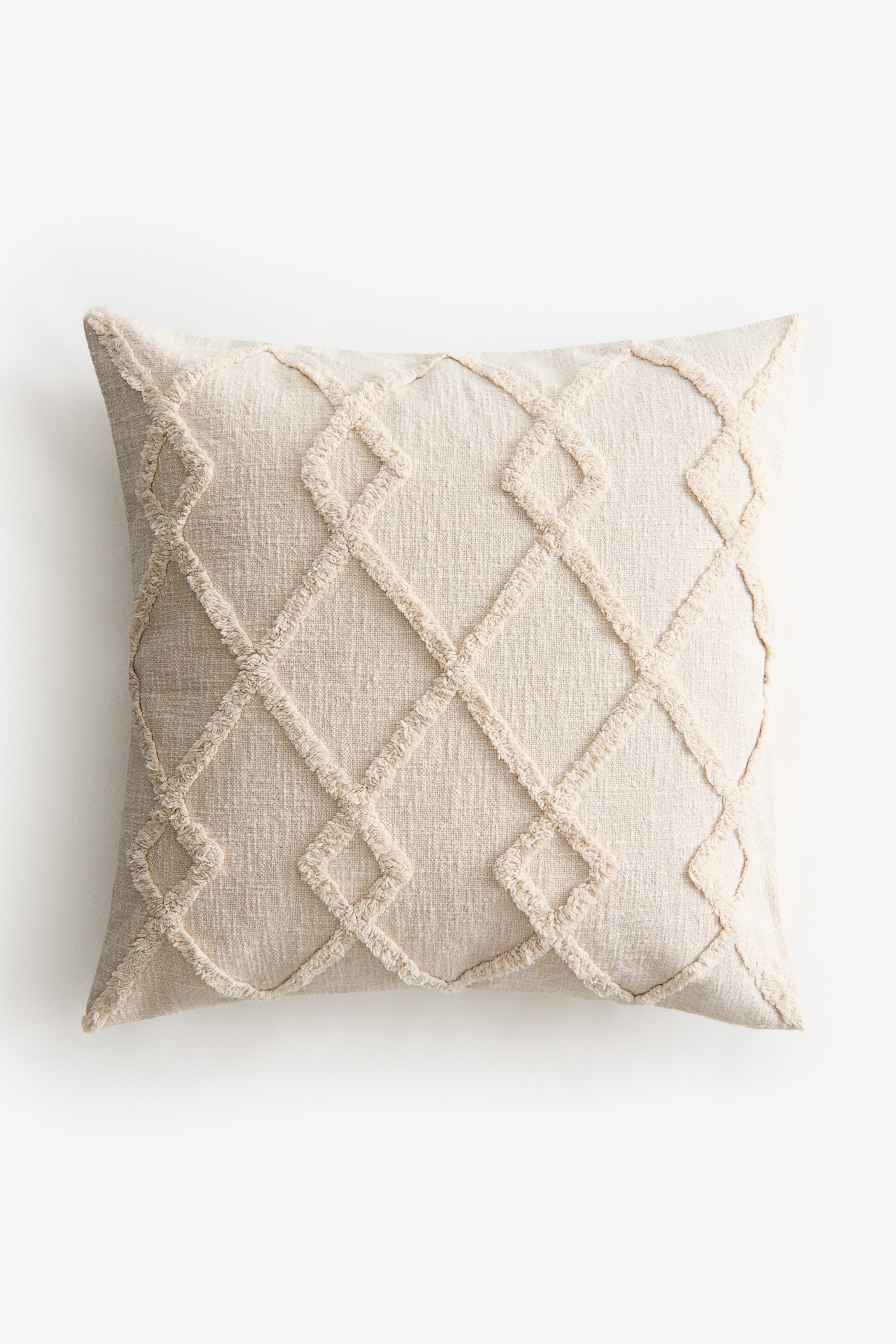 Zobacz większy obraz: Jasno-beżowa kwadratowa poduszka prezentuje swoją przód, z ozdobnym wzorem w teksturowane romby. Linia rombów jest tworzona przez podniesione, strzępiaste wypustki na tle płaskiej tkaniny.
