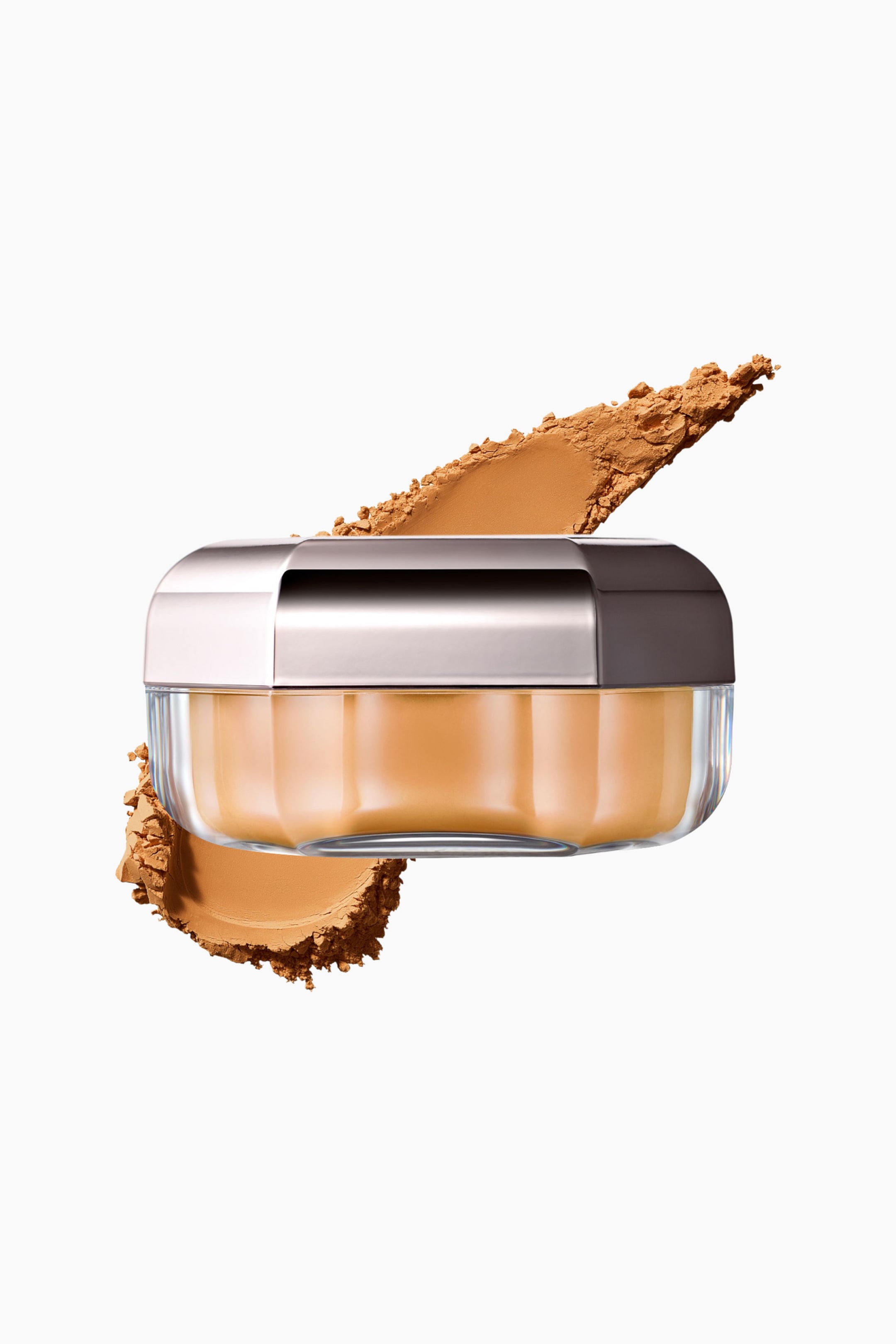 Näytä suurempi kuva: Set It Down Superfine Blurring Setting Powder leijuu kirkkaassa, särmikkäässä purkissa, jossa on metallinhohtoinen hopeakorkki, ja esittelee lämpimän sävyistä tan-väriä. Purkin takana kulkee vinottain saman sävyisen irtopuuterin sivelyjälki, joka tuo esiin sileän rakenteen ja murenevat reunat.
