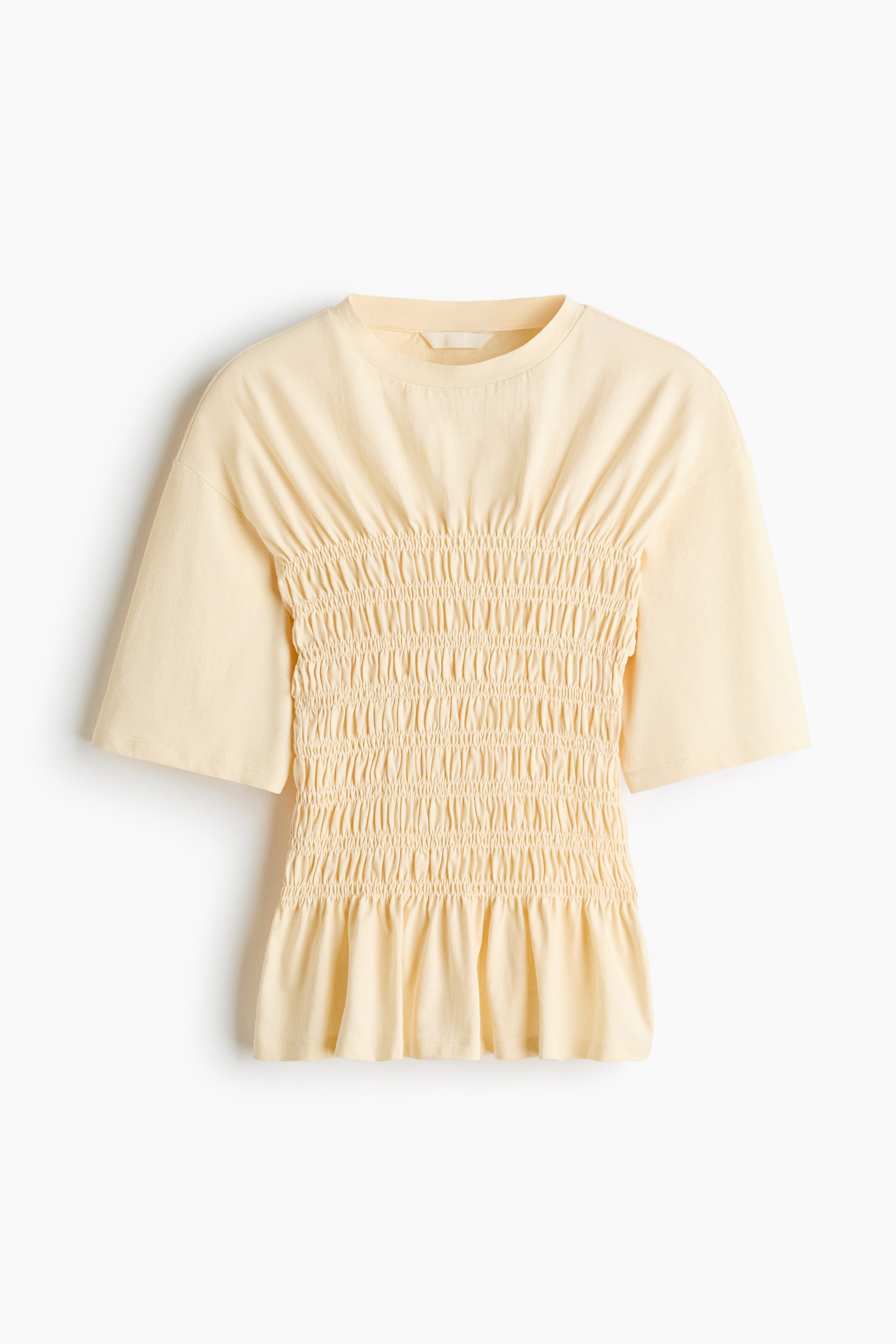 View larger image: A pale yellow smocked T-shirt in cotton jersey is facing front, featuring a round neckline and gently dropped shoulders. The mid-section showcases extensive horizontal smocking, forming a fitted bodice that flares slightly at the hem.