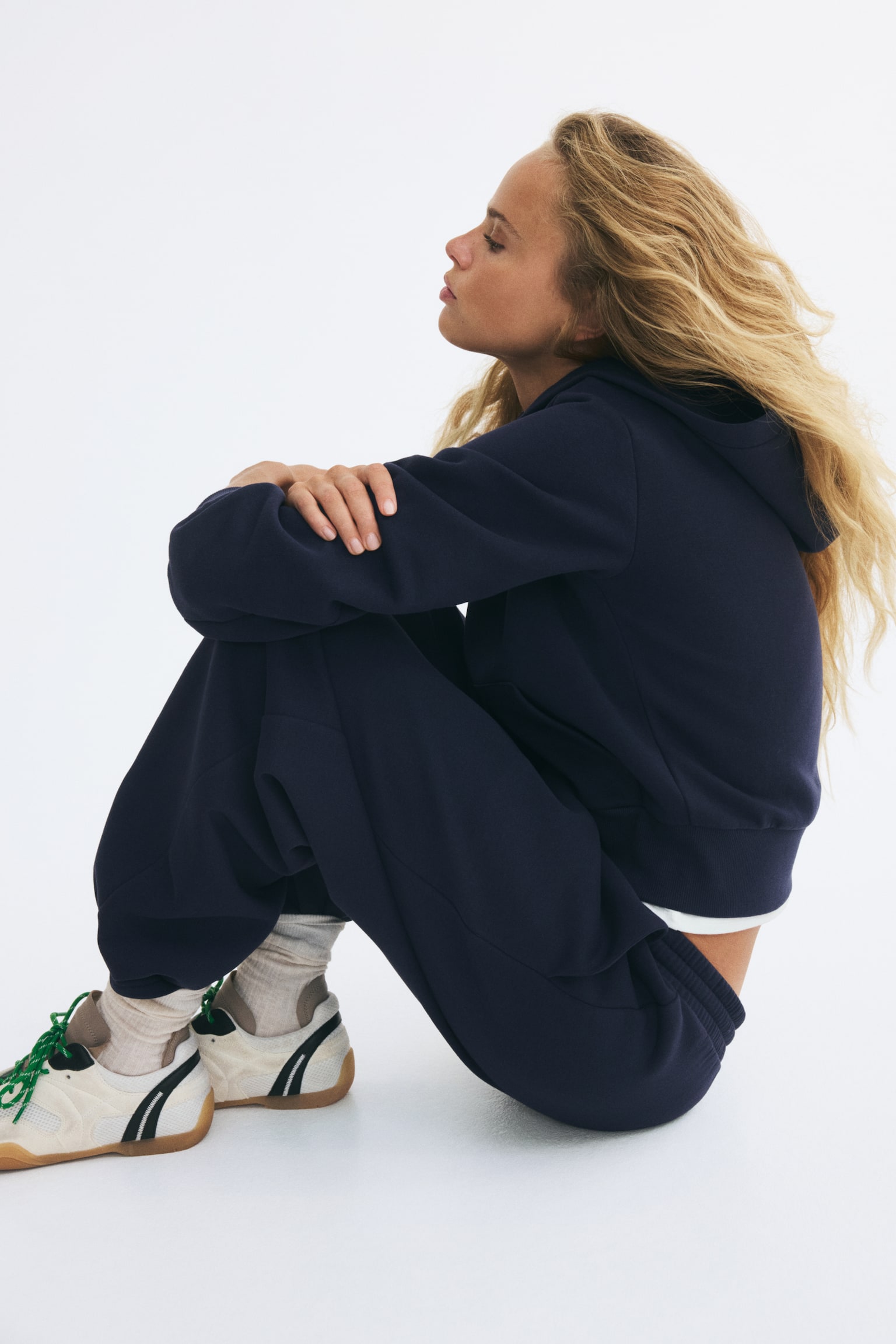 Die marineblauen Jogginghosen sind von vorne zu sehen und zeichnen sich durch eine entspannte, strukturierte Passform mit einem elastischen, gerippten Bund und passenden Kordeln aus. Das Design zeigt seitliche Eingrifftaschen sowie sauber gearbeitete, offene BeinabschlÃ¼sse an den KnÃ¶cheln. - 1