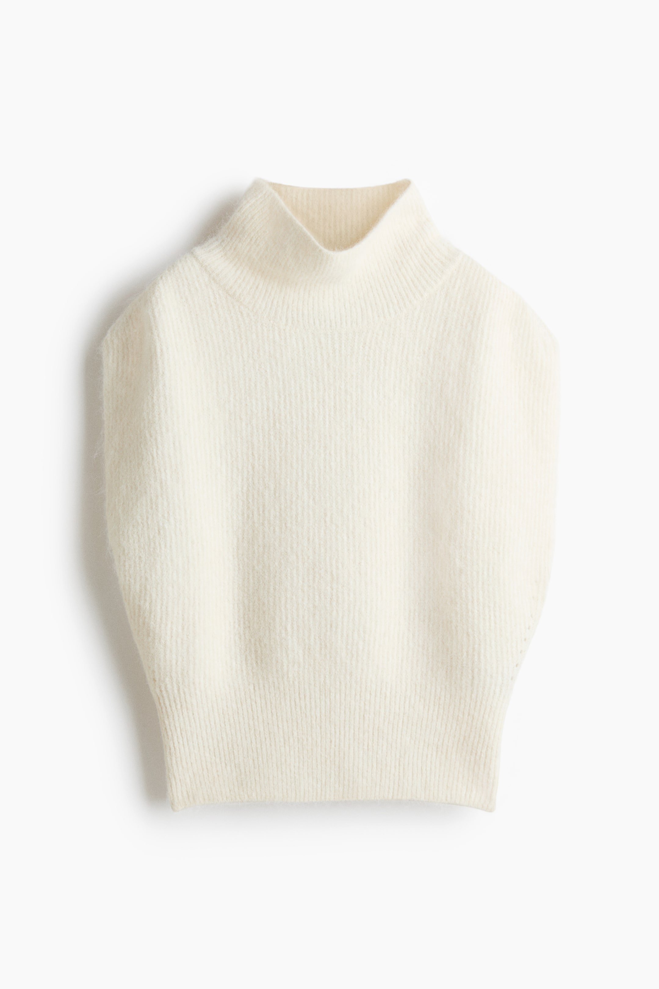 View larger image: A cream sleeveless sweater is laid flat, facing forward, displaying a mock neck, a vertically ribbed knit body, and a distinct ribbed hem.
