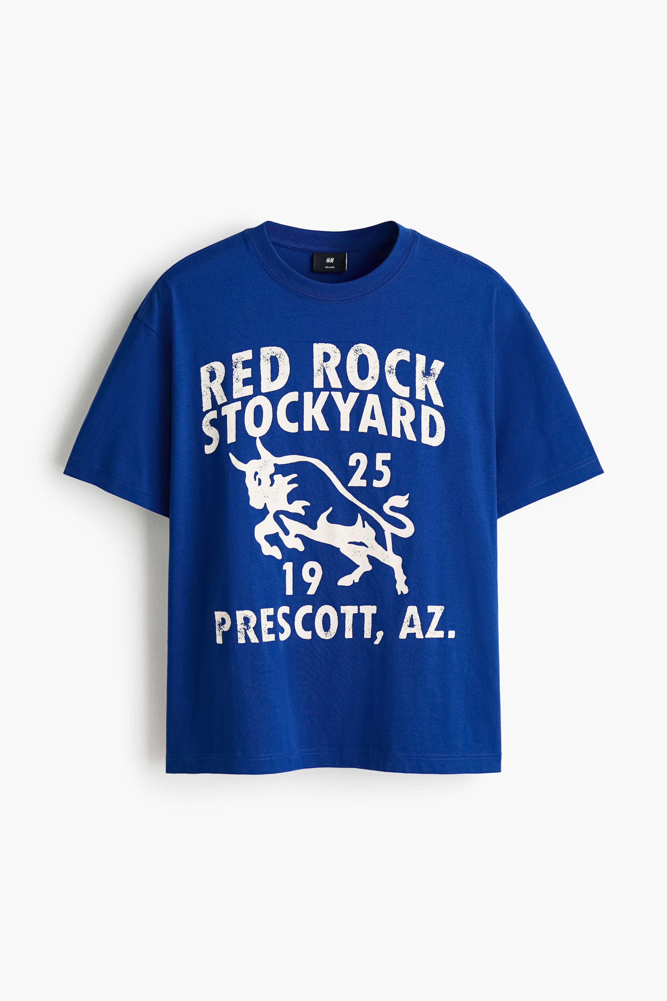 View larger image: A blue T-shirt crafted from midweight cotton jersey showcases a white distressed graphic print on its front. The print displays "RED ROCK STOCKYARD" above a charging bull design, with "25" and "19" flanking the bull, and "PRESCOTT, AZ." below. It features a round, rib-trimmed neckline, dropped shoulders, and a straight-cut hem, offering a relaxed fit.