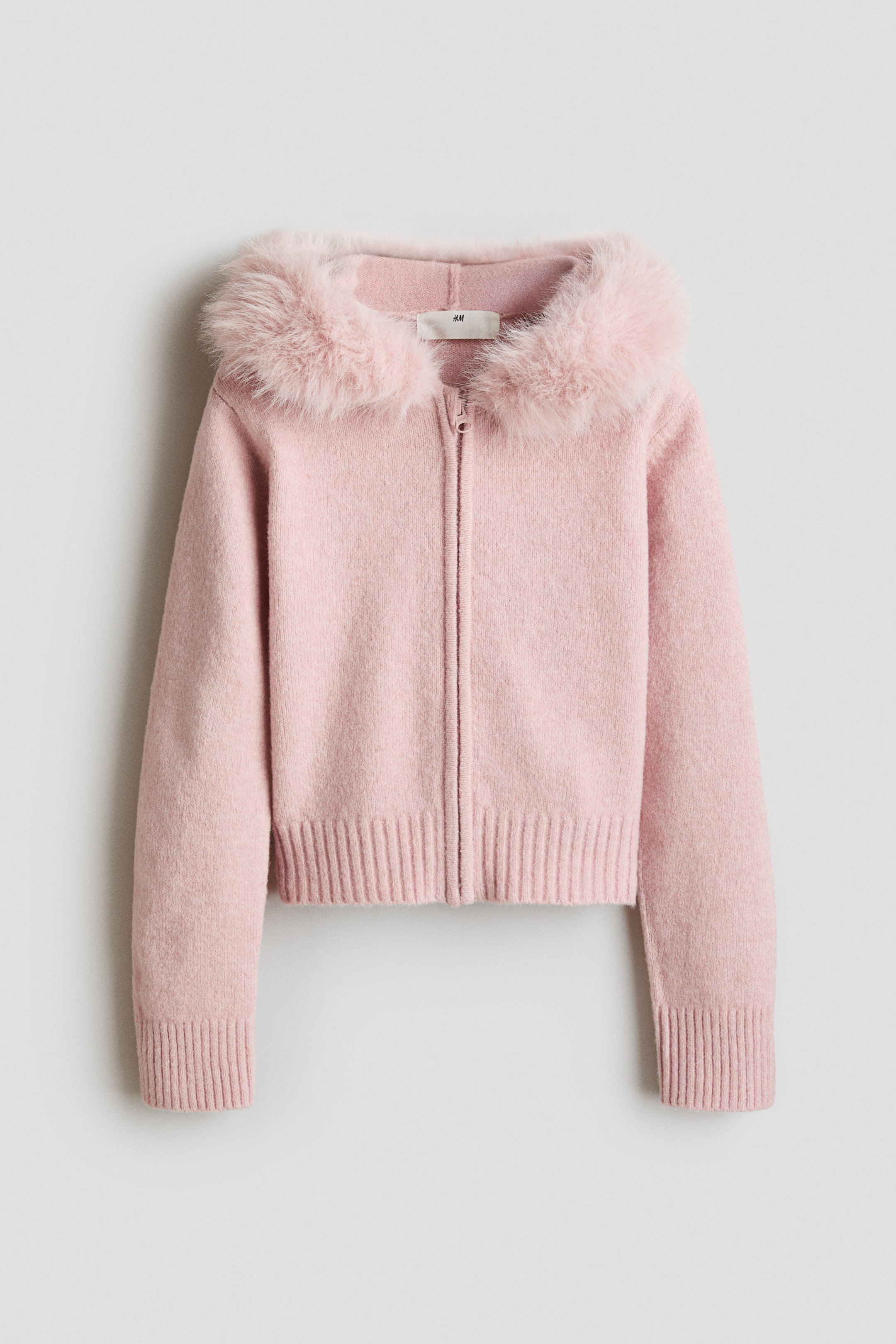 View larger image: A pink knitted cardigan features a faux fur collar and a full-length front zipper closure. It also has long sleeves with ribbed cuffs and a ribbed hem.