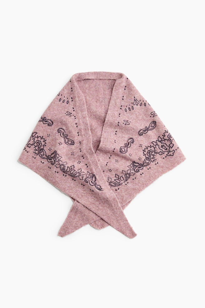 A heathered pink knit scarf is lying flat in a triangular shape from the front, with its tapered ends crossing at the bottom. The scarf is featuring a dark purple paisley and floral border pattern and a ribbed neckline trim. - 1