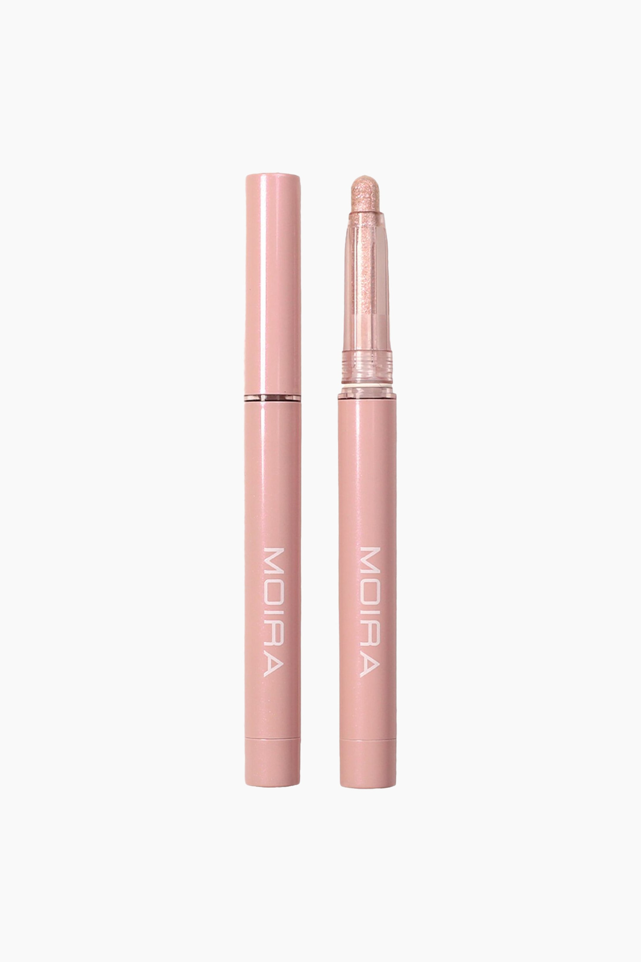 Visa större bild: Stellar Glaze Stick Shadow visas som två vertikala, ljusrosa cylindriska pennor som står sida vid sida, där den ena visas helt korkad och den andra utan kork. Den okorkade pennan visar en rundad, skimrande champagne-rosa krämögonskugga i en transparent plastkrage. Båda pennorna har varumärkesnamnet "MOIRA" tryckt vertikalt i vita bokstäver på den nedre delen av skaftet.
