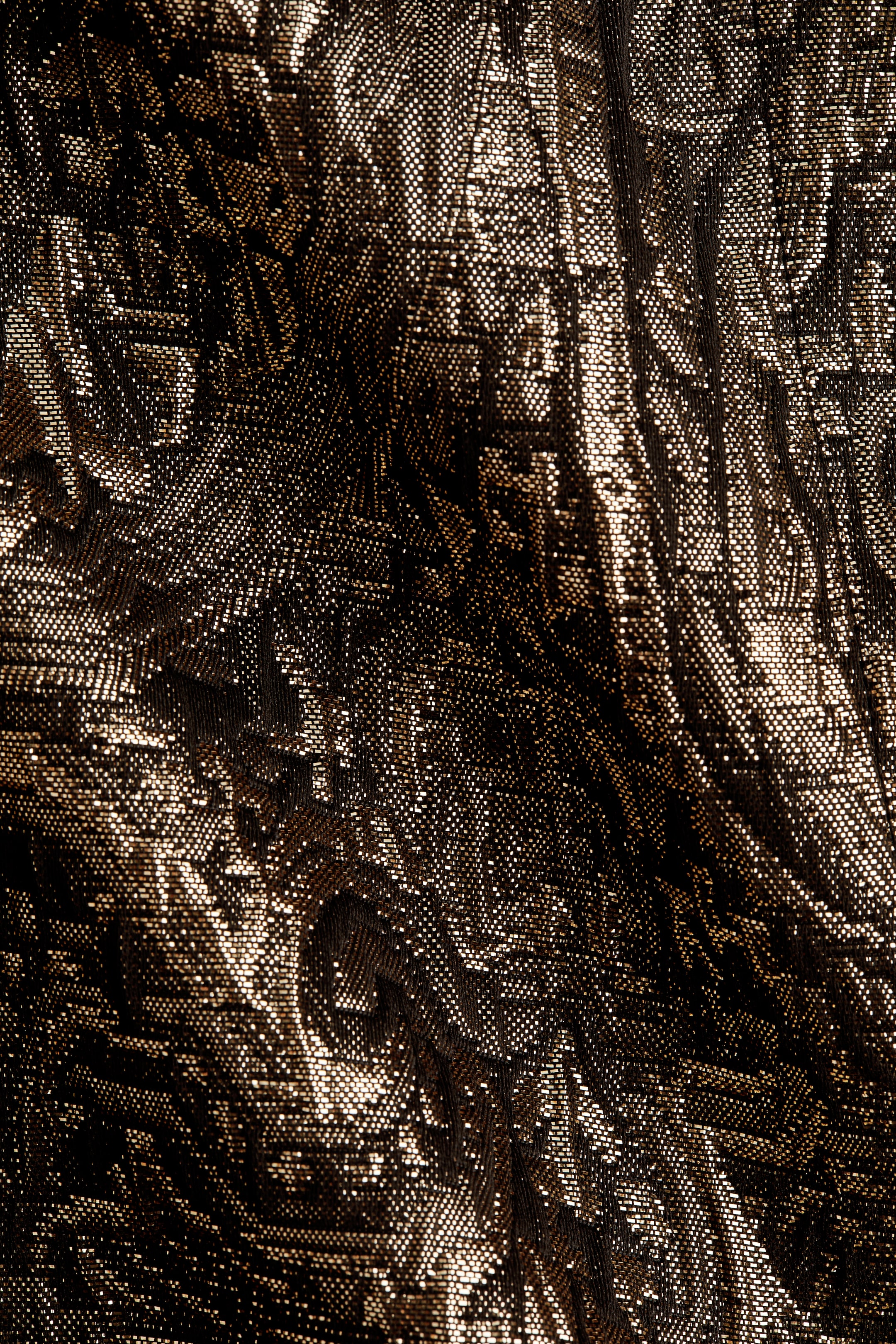 Zobacz większy obraz: Bluzka prezentuje zbliżenie na swoją solidną, ciemną tkaninę, która połyskuje metalicznymi złotymi nitkami tworzącymi teksturowany wzór.