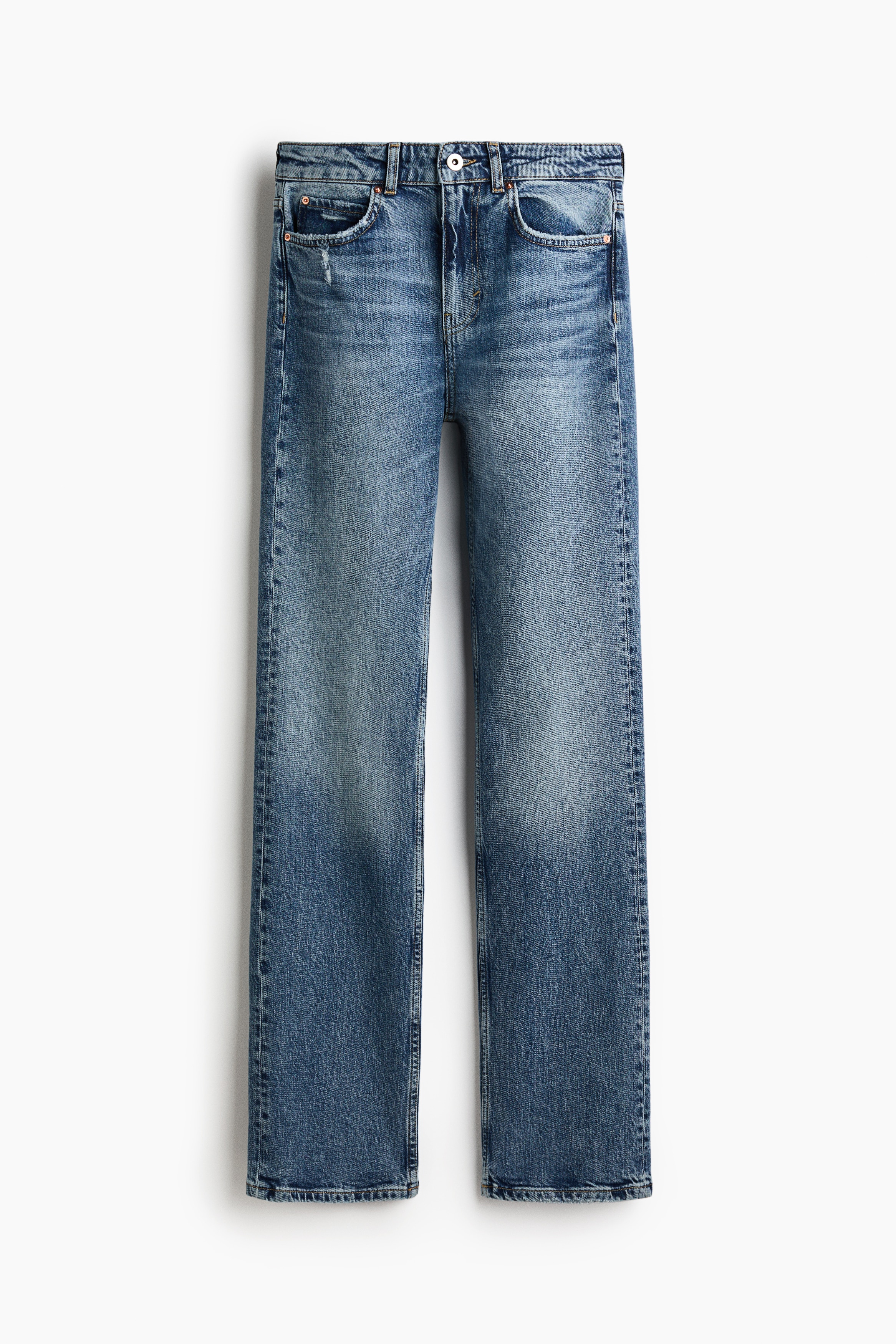 Jeans de ganga azul de perna reta com cinco bolsos e lavagem azul mÃ©dia, usados pelo modelo. Os jeans sÃ£o combinados com um cinto preto fino e um blazer preto Ã s riscas finas, com o modelo de pÃ© e uma mÃ£o pousada junto Ã  cintura.