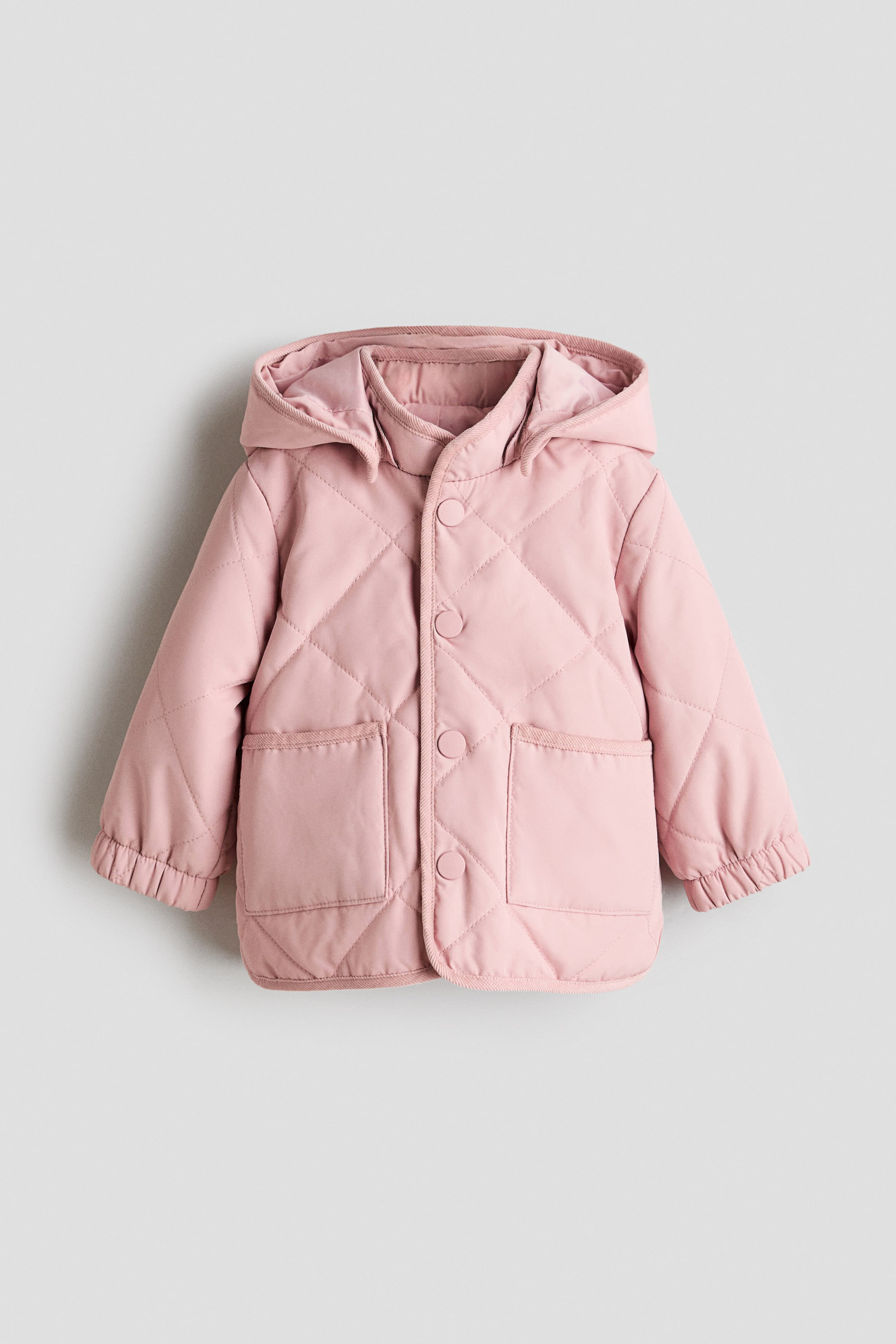 View larger image: A pink, lightly padded jacket is showcasing a front view, characterized by a quilted diamond weave. It also features corduroy trims, a detachable hood, a stand-up collar, press-studs down the front, two patch front pockets, and elasticated cuffs.