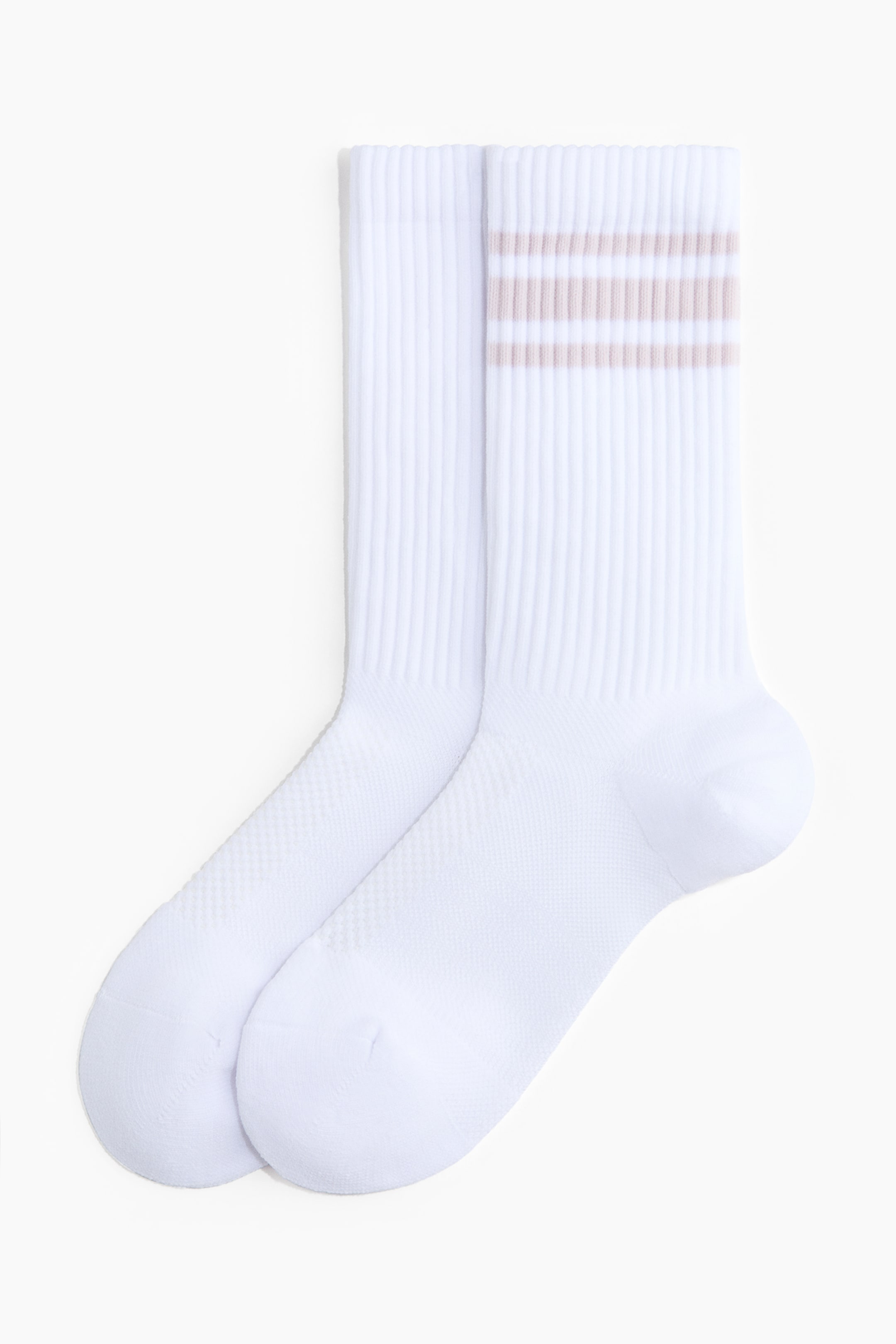 View larger image: A pair of white socks lies side-by-side, displaying ribbed cuffs. One sock features three light brown stripes around its cuff, while both socks showcase a finer knit texture on the foot and toe sections.