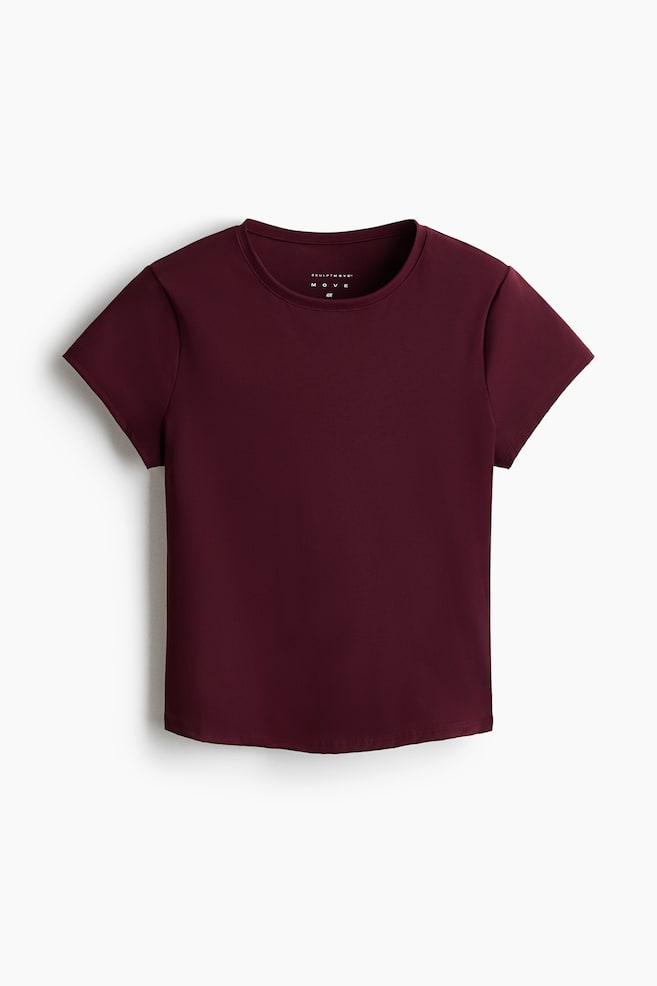 Een bordeauxrood t-shirt met korte mouwen heeft een ronde hals en een gladde, aansluitende uitstraling. Het is plat neergelegd vanuit een vooraanzicht, met een klein merkje zichtbaar aan de binnenkant van de halslijn. - 1