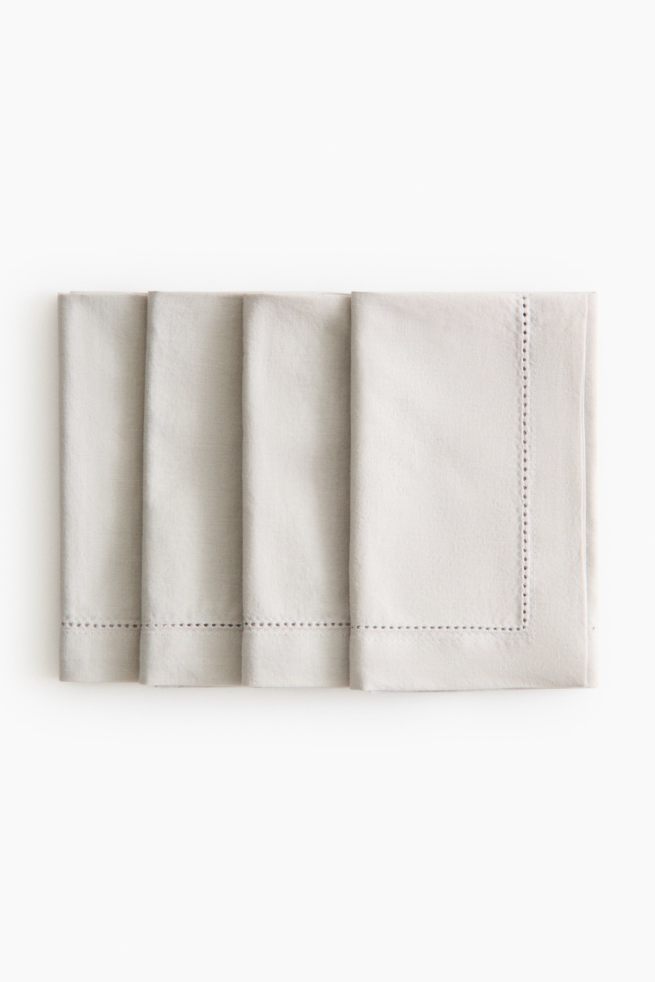 Grösseres Bild ansehen: Vier hellfarbige Baumwoll-Canvas-Servietten sind nebeneinander angeordnet, mit der Vorderseite nach vorne, wobei jede Serviette mit Hohlsaumdetails entlang ihrer fertigen Kanten versehen ist.