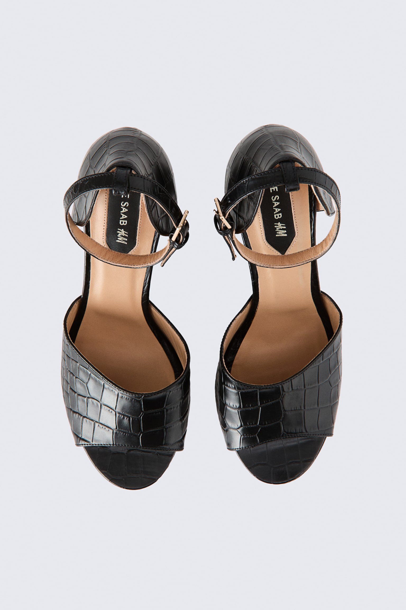 A pair of black croc-effect leather heeled sandals is shown from a top-down view, featuring an open peep-toe design and beige insoles. The sandals come with adjustable ankle straps with gold-tone buckles and a textured, embossed finish.