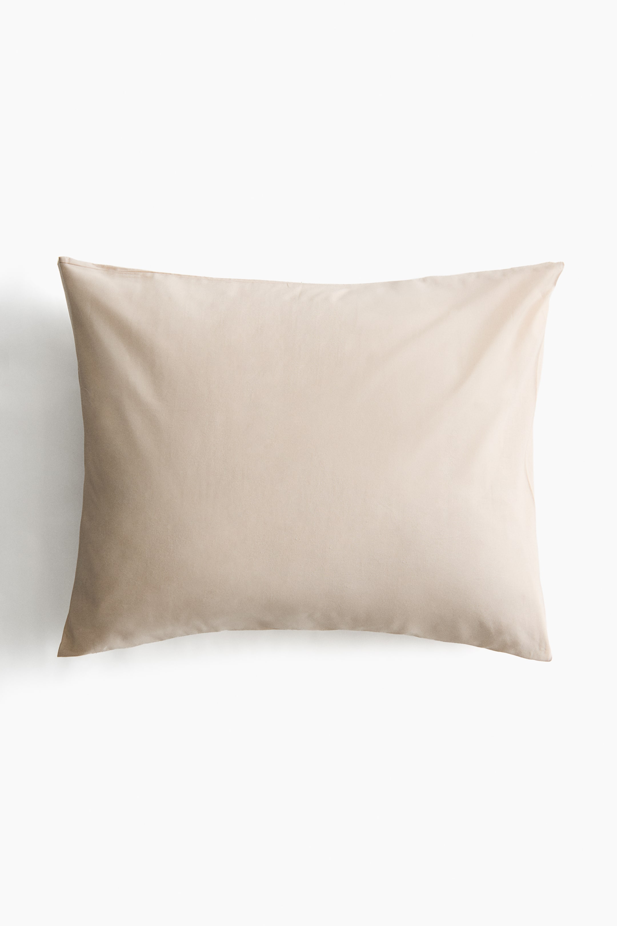 Ampliar la imagen: Una funda de almohada beige claro presenta su parte frontal, mostrando un tejido de algodón de hilo fino y suaves pliegues a lo largo de su superficie.