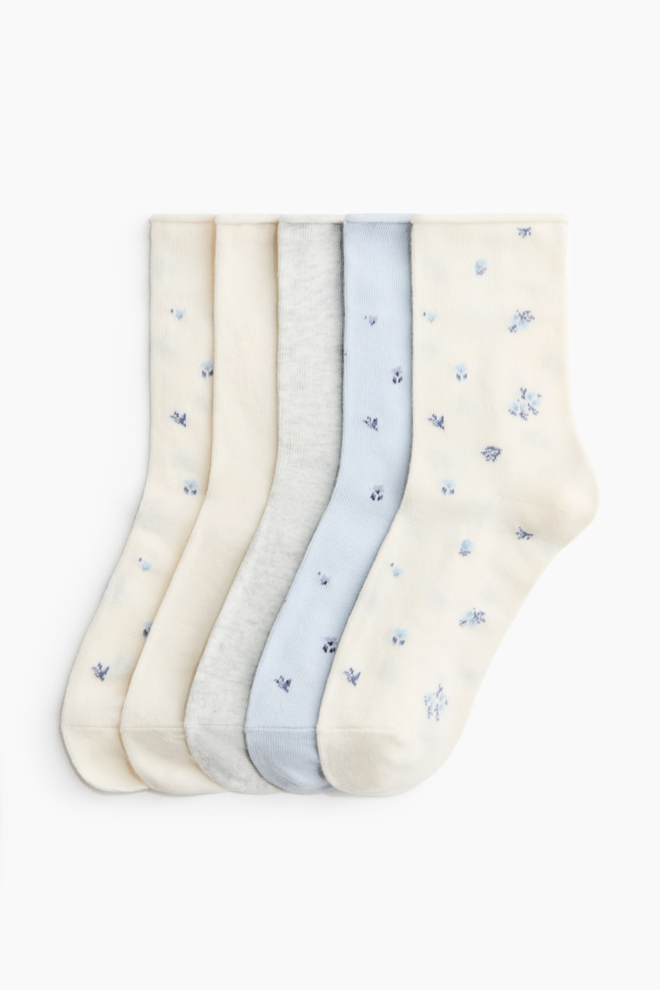 Voir une image plus grande: Cinq chaussettes sont posées à plat, partiellement superposées. Deux en crème et une en bleu pâle présentent de petits motifs floraux bleus. Une en crème et une autre en gris chiné affichent des couleurs unies.