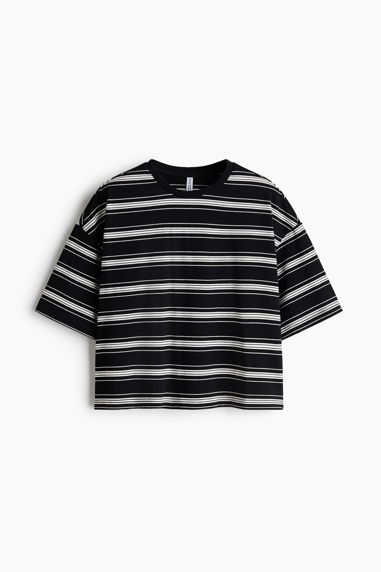 A black-and-white horizontally striped T-shirt is shown from the front, featuring a crew neck, drop shoulders, and wide, short sleeves in an oversized, cropped fit. The garment displays a repeating pattern of thin white stripes on solid black fabric.