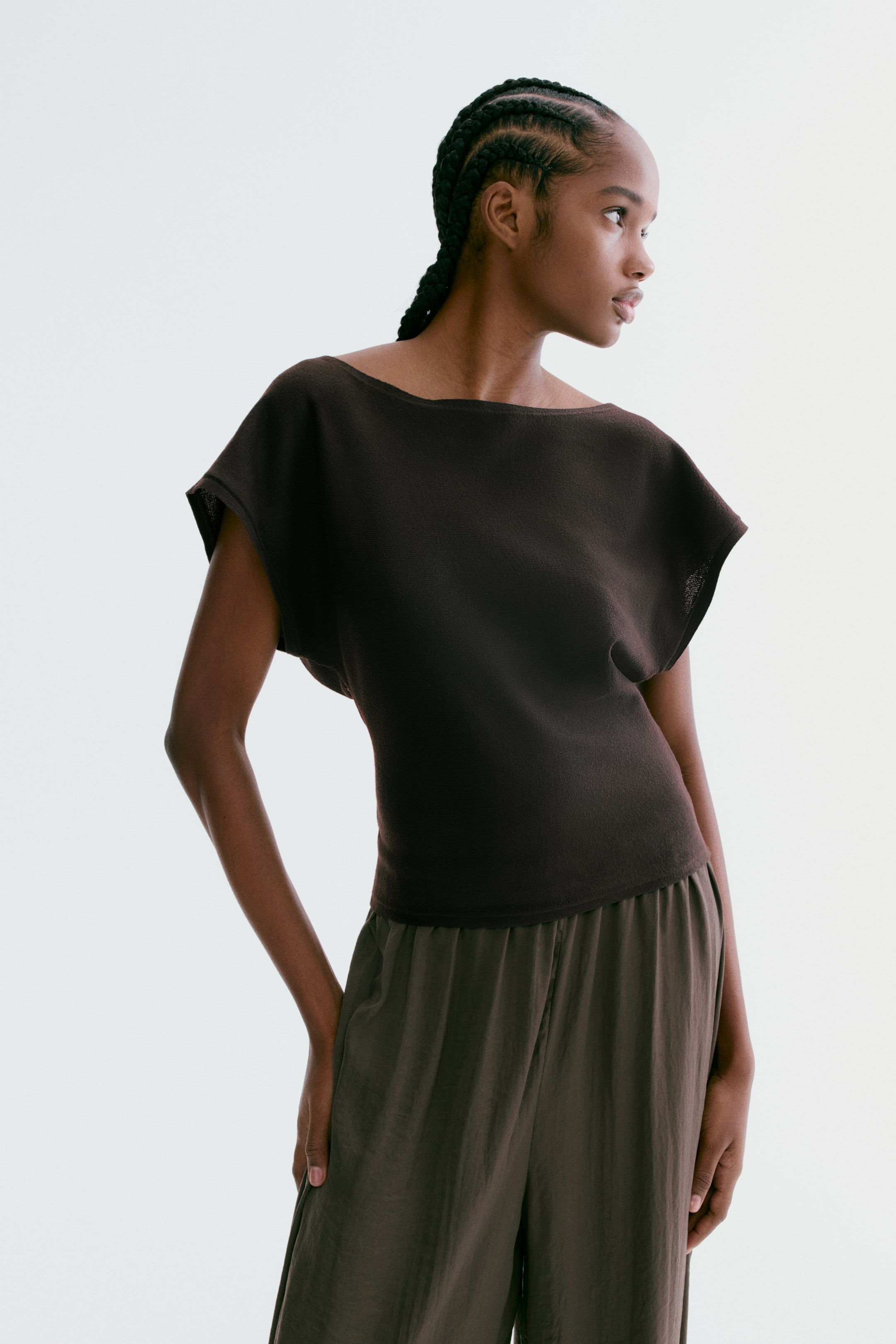 View larger image: A dark brown boat neck top featuring short dolman sleeves. It presents a relaxed silhouette, gently tapering at the waist and ending with a straight hem at the hip.