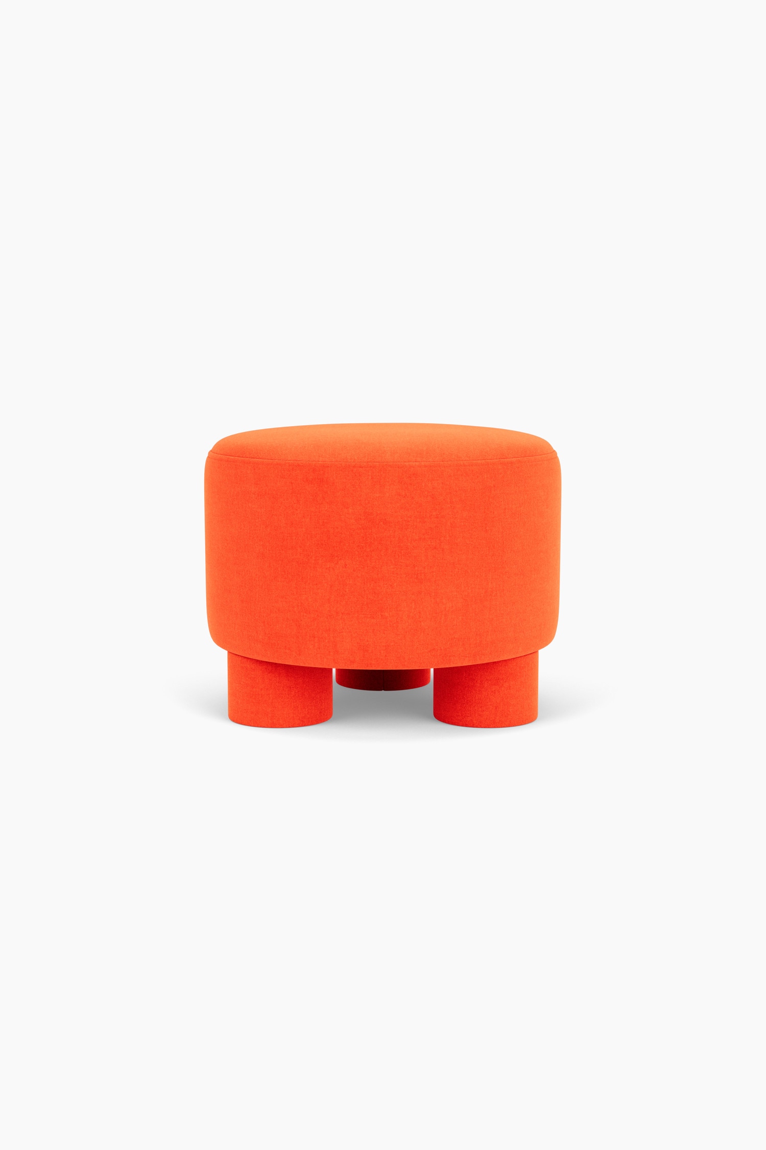 Un pouf cylindrique en velours orange repose sur trois pieds rembourrÃ©s Ã©pais assortis, mettant en valeur une assise lisse et arrondie au design sans couture.