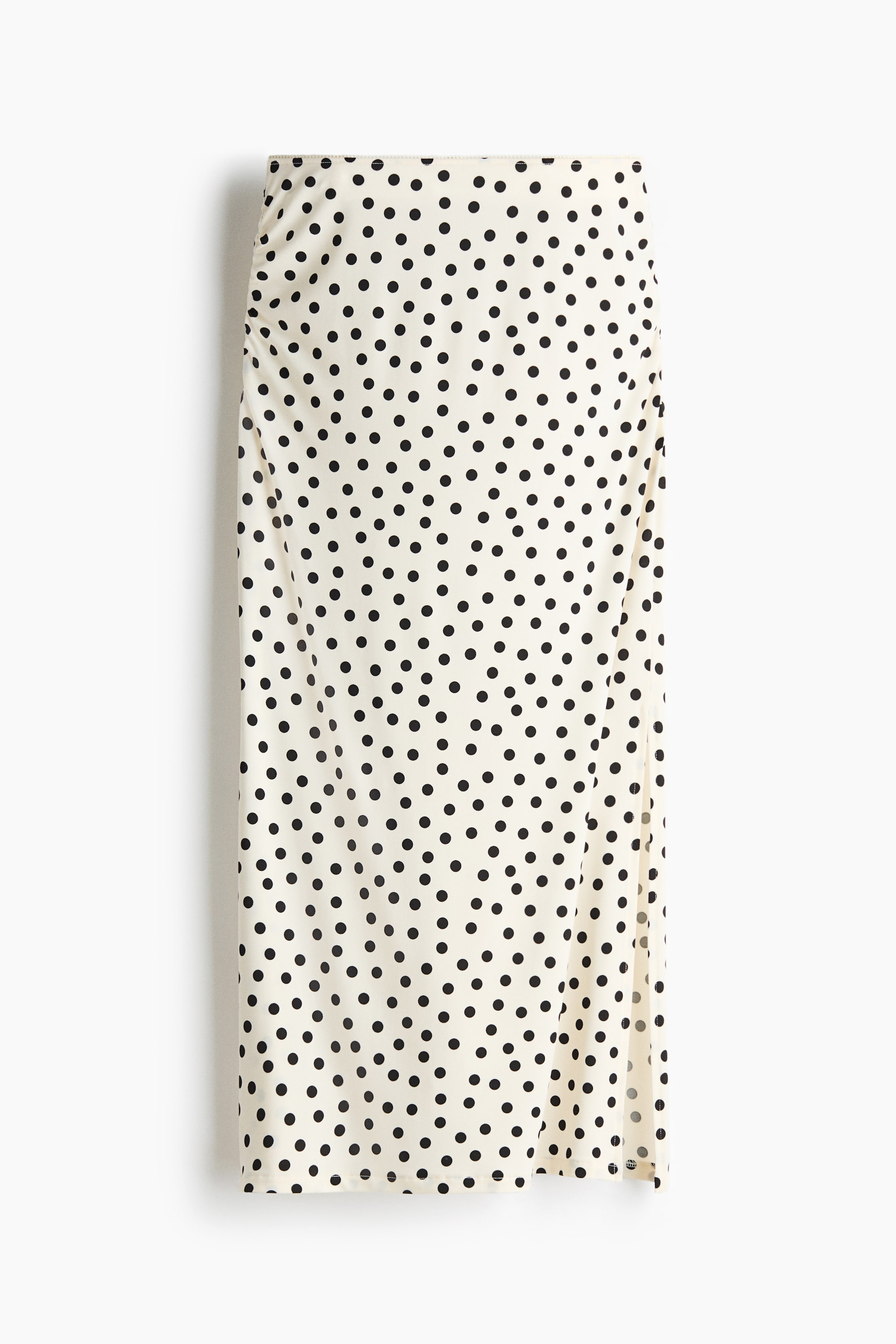 View larger image: A cream midi skirt with black polka dots features a right-side slit and vertical ruching along the left side.