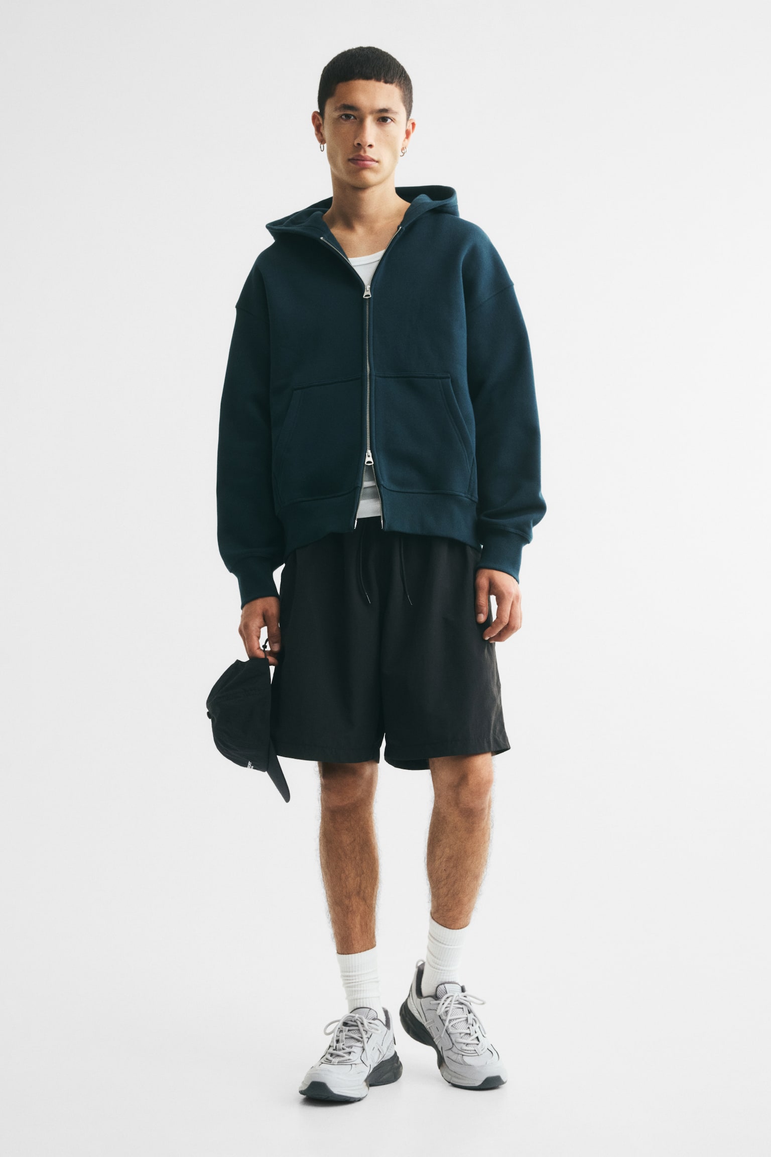 A dark teal zip-up hoodie is displaying a relaxed fit from the front, featuring a full-length silver-toned zipper, a hood, a split kangaroo pocket, ribbed cuffs, and a ribbed hem. - 1
