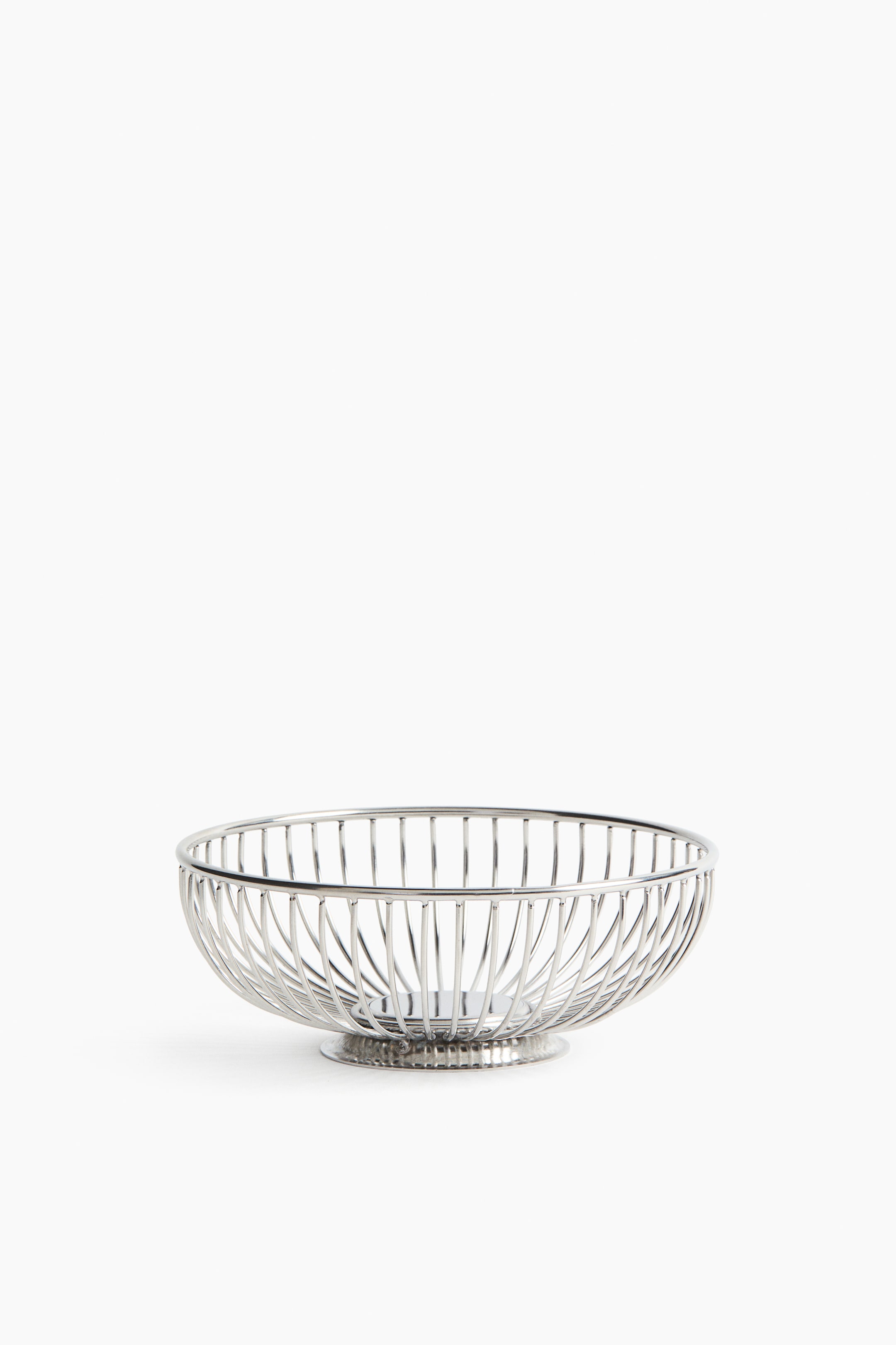 Voir une image plus grande: Un panier en fil argenté présente une forme ronde, semblable à un bol, construit à partir de fils verticaux fins, et repose sur une base circulaire texturée.