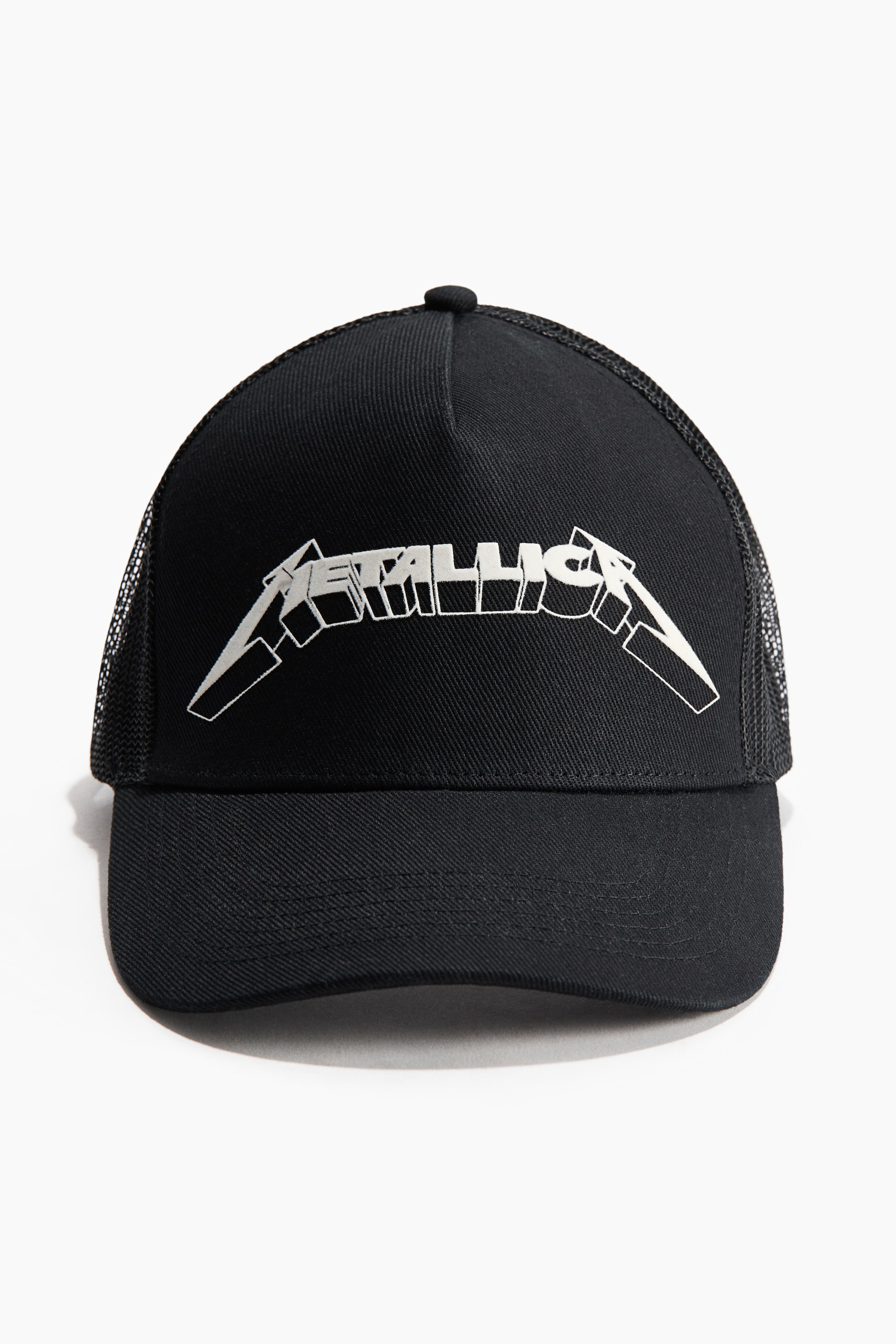 View larger image: The black trucker hat is oriented forward, showcasing a metallic silver 3D "METALLICA" logo prominently on its solid black front panel. It features black mesh on the sides and back, complemented by a curved black brim.